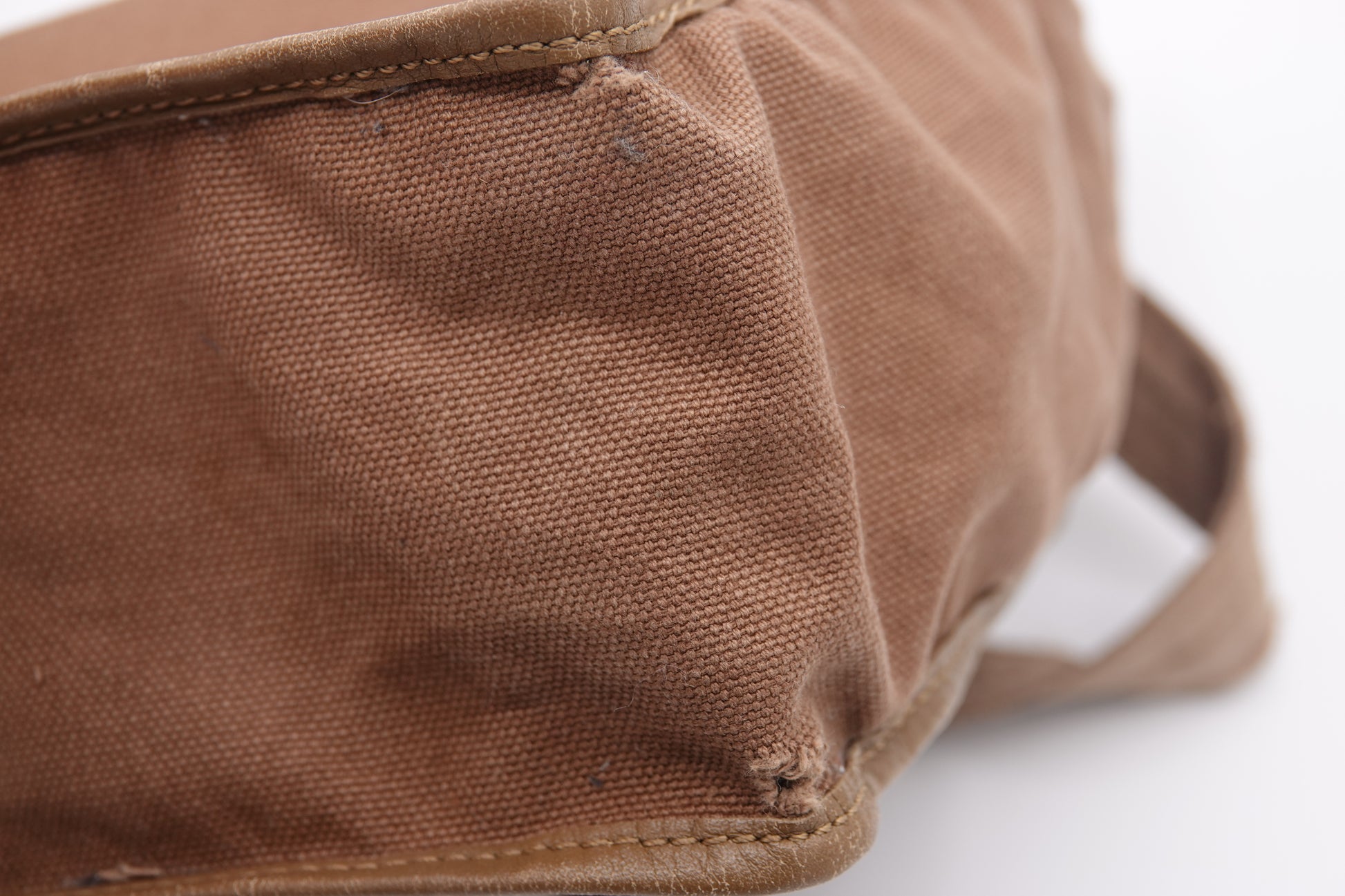 Close-up of a brown fabric bag with visible texture on a white background
