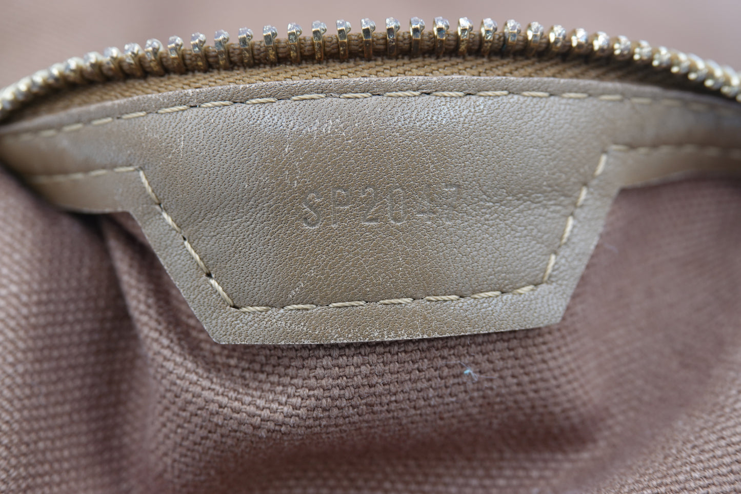 Close-up of a beige fabric surface with a visible brand label.