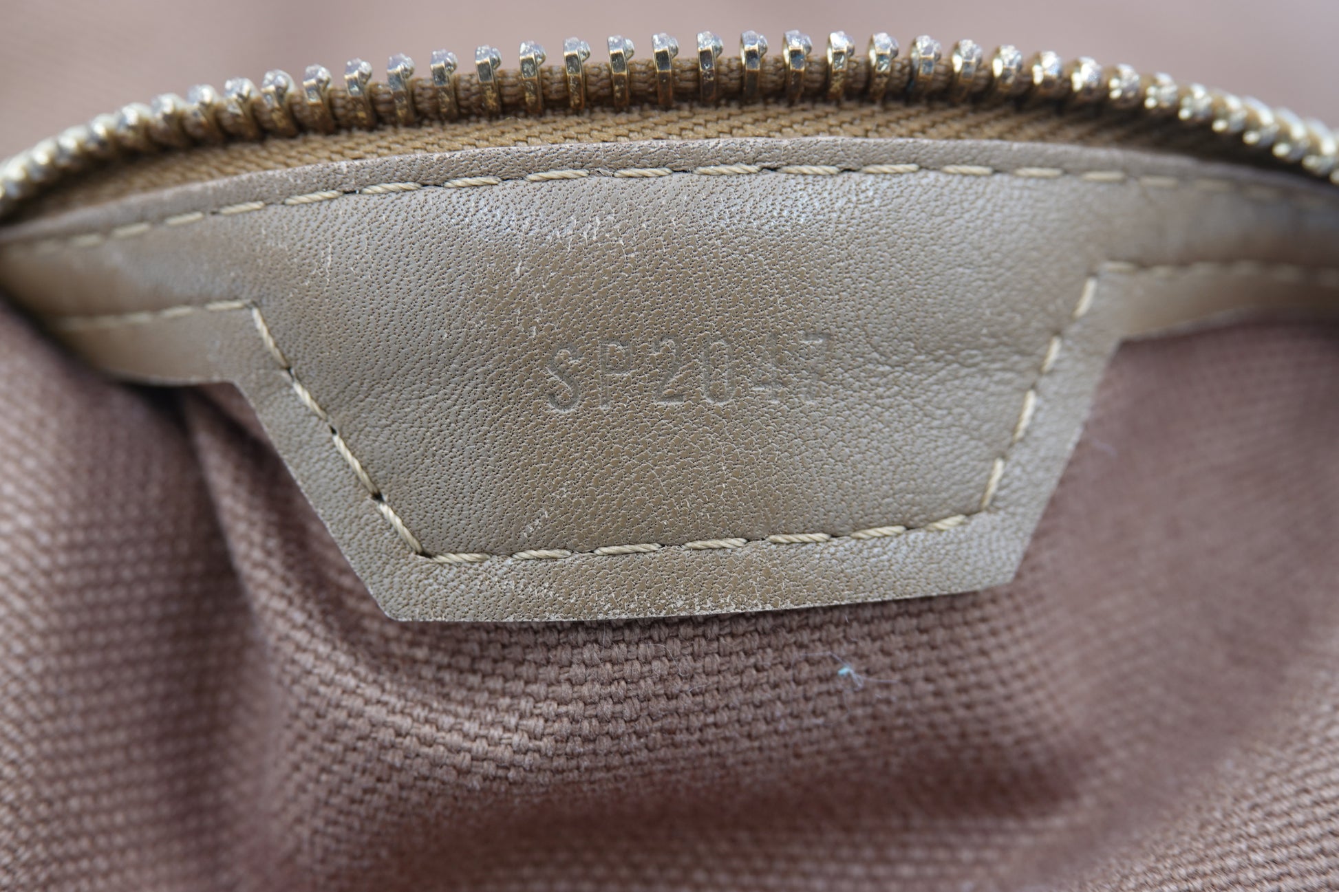 Close-up of a beige fabric surface with a visible brand label.