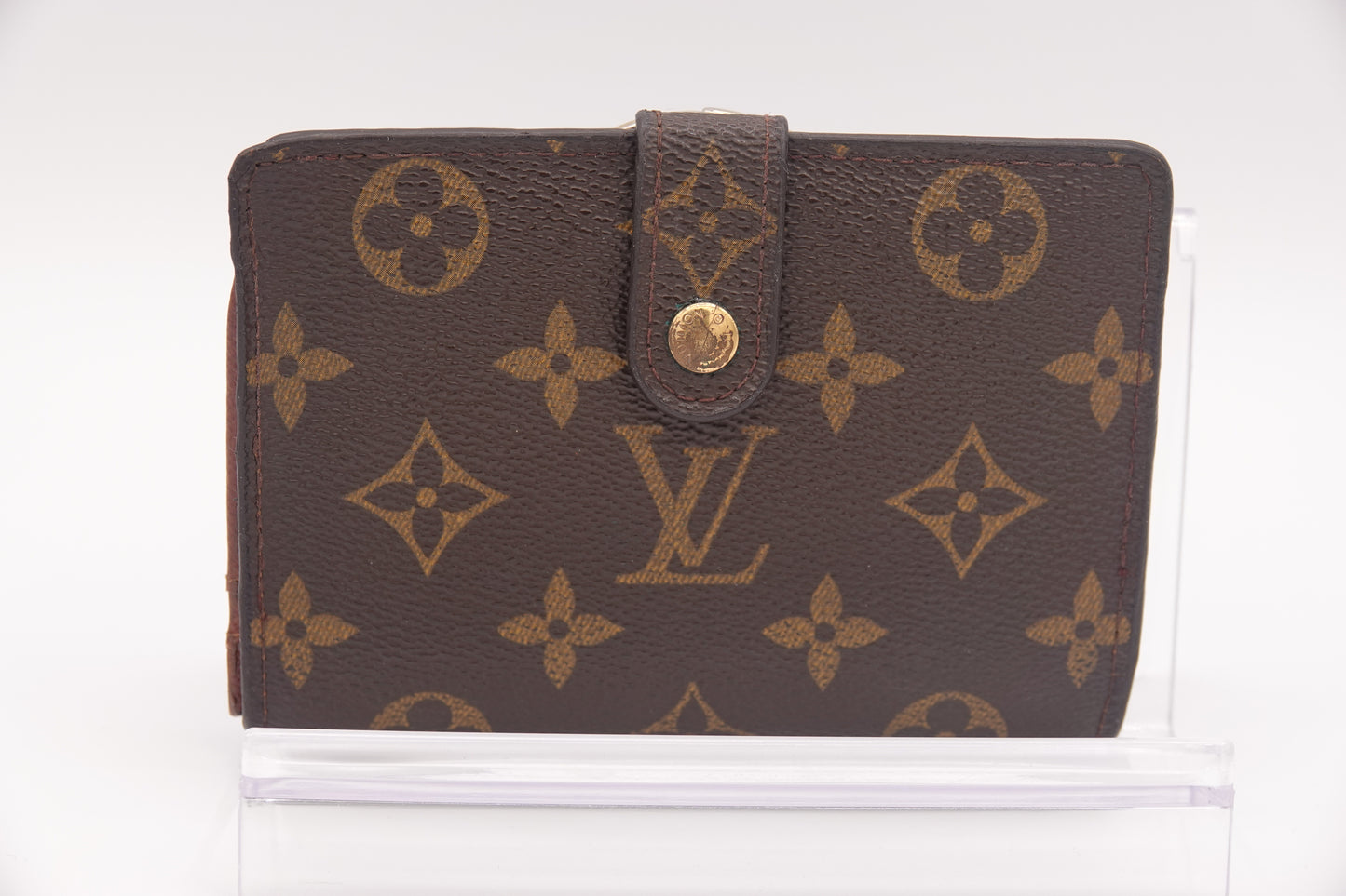 Brown wallet with gold monogram pattern on a white background