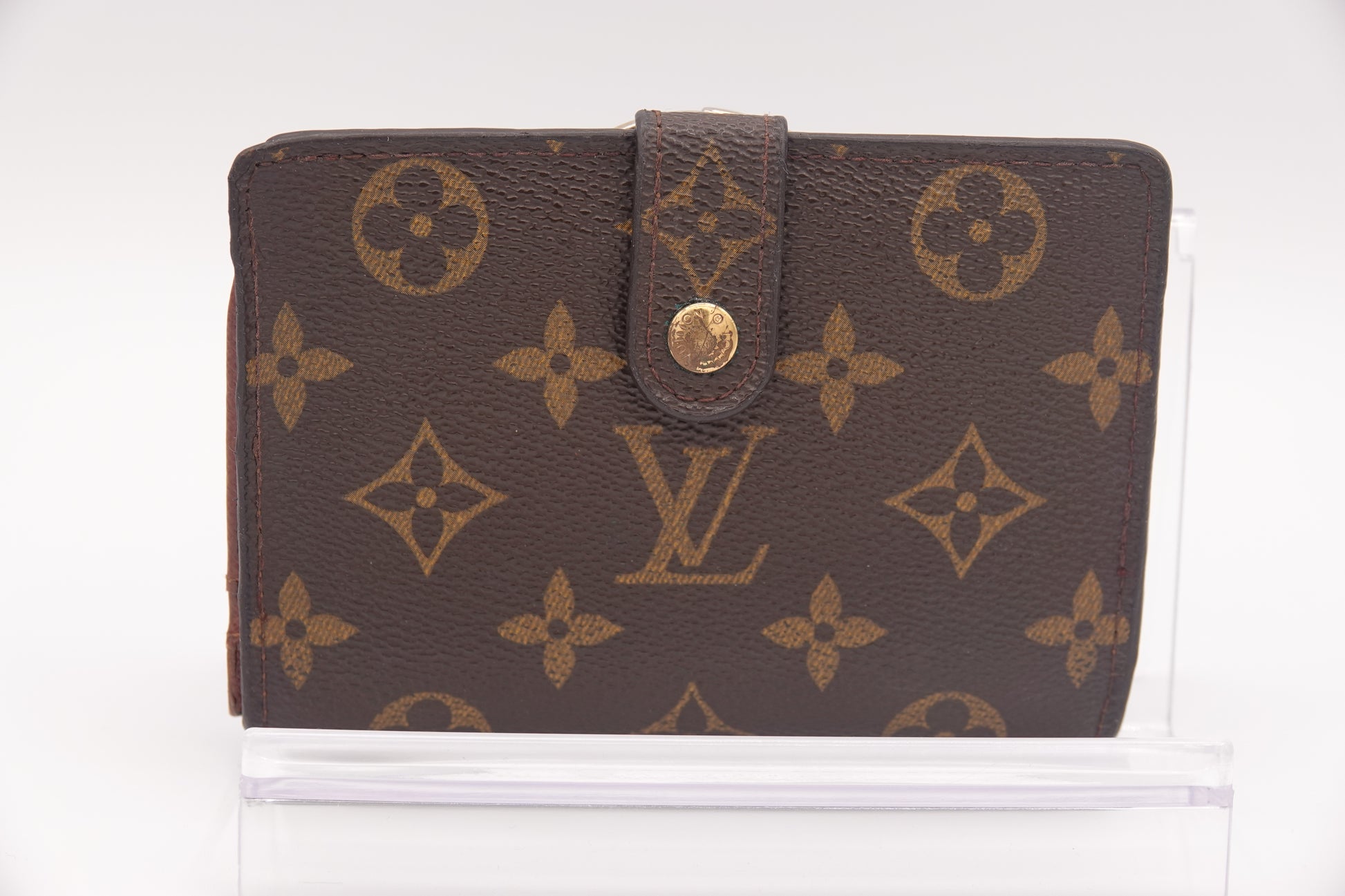 Brown wallet with gold monogram pattern on a white background