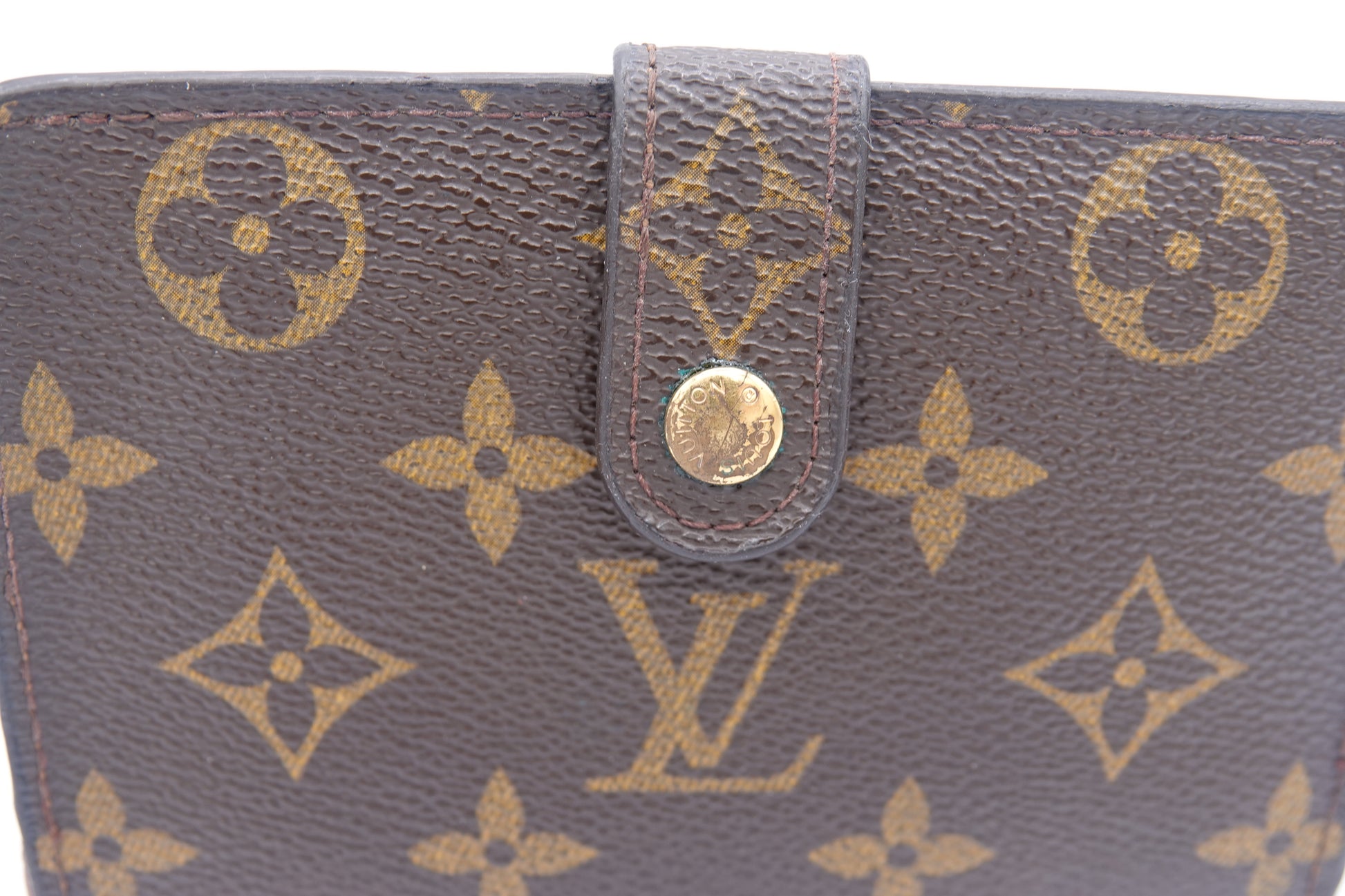 Close-up of a brown wallet with gold monogram pattern