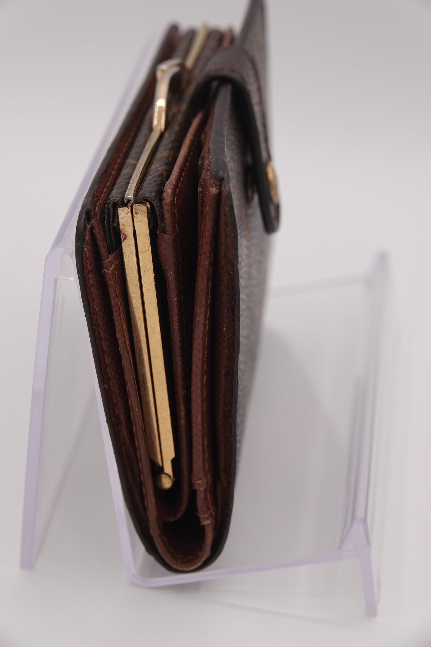 Close-up of a brown leather wallet with gold accents on a white background