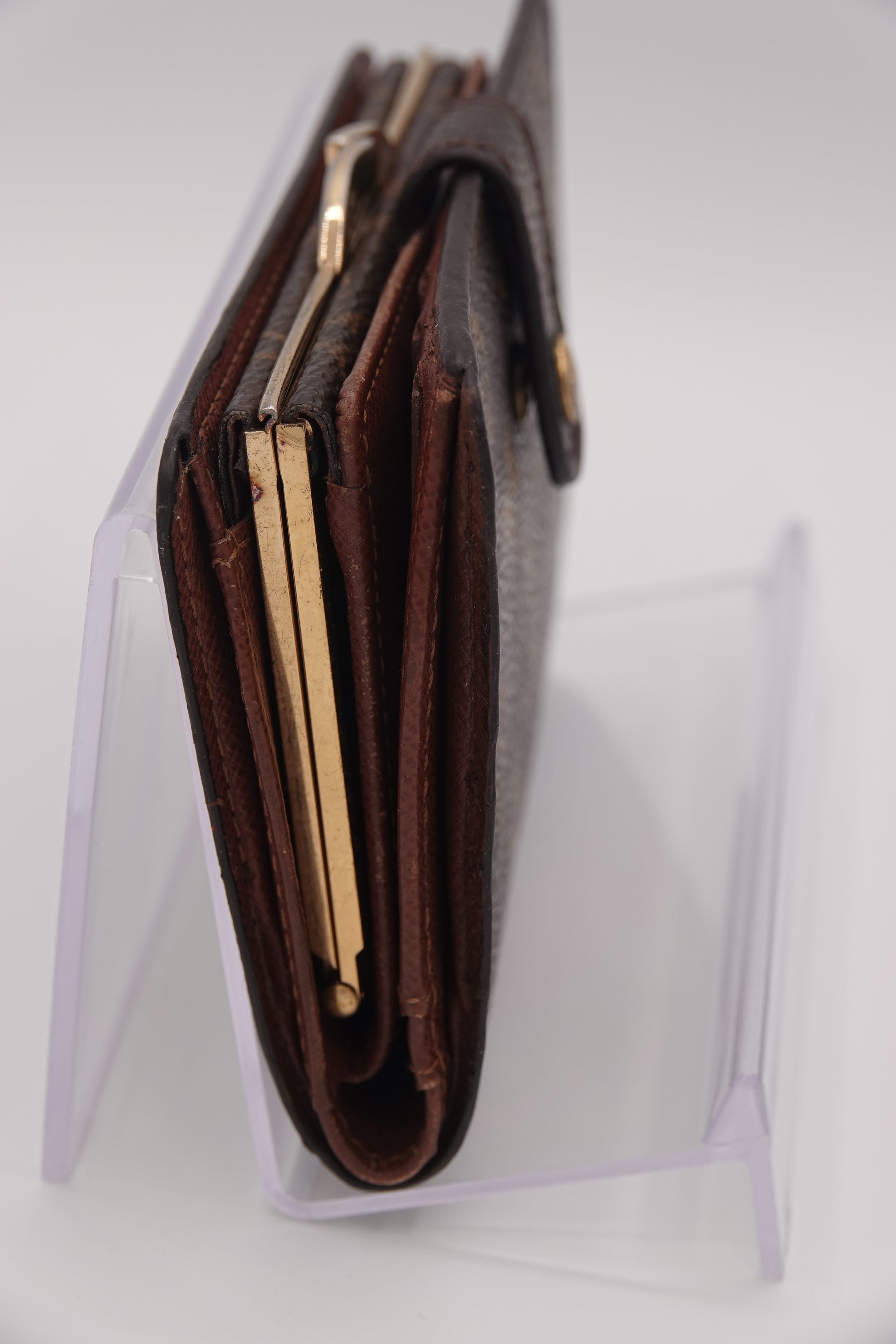 Close-up of a brown leather wallet with gold accents on a white background