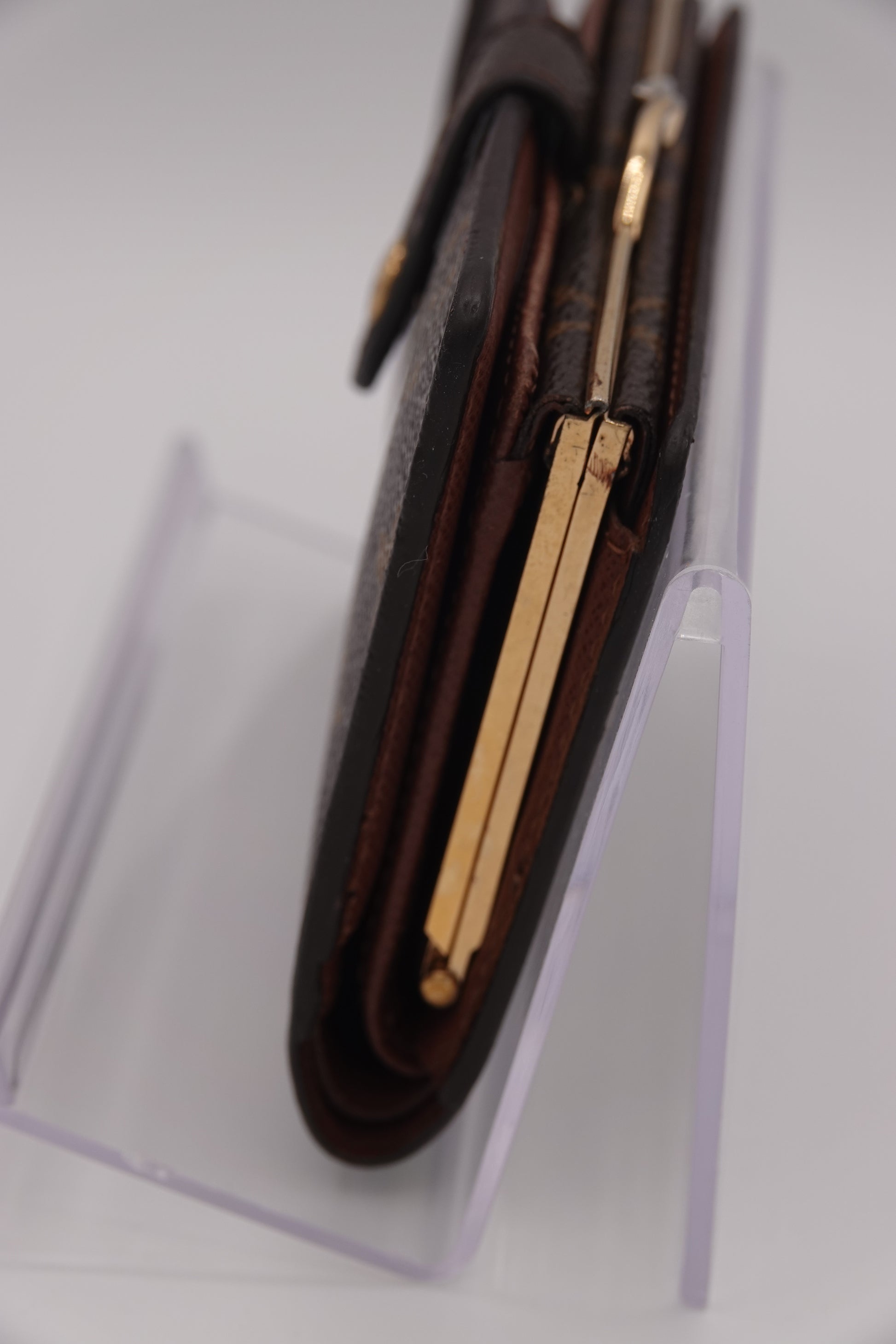 Close-up of a brown leather wallet with gold accents on a white background