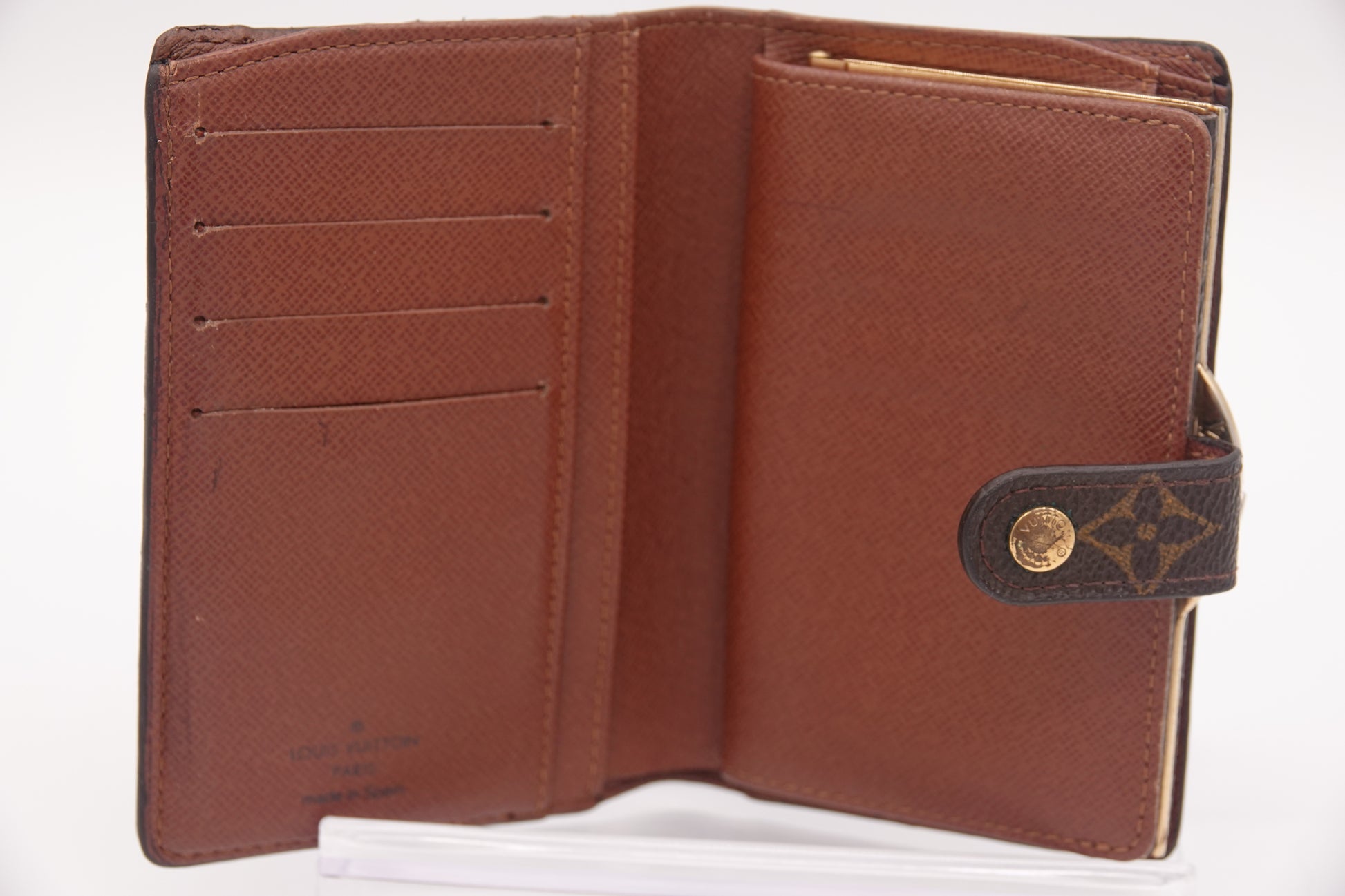 Brown leather wallet with gold emblem on a white background