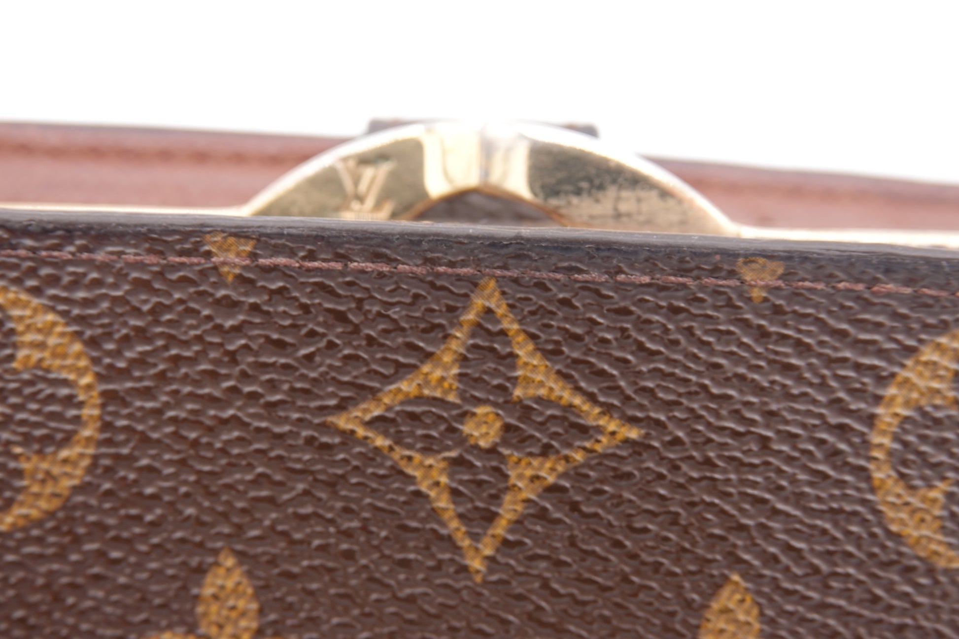 Close-up of a brown leather Louis Vuitton wallet with gold emblem.
