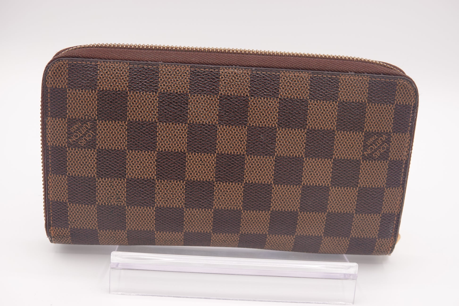 Brown checkered wallet with brand logo on a white background