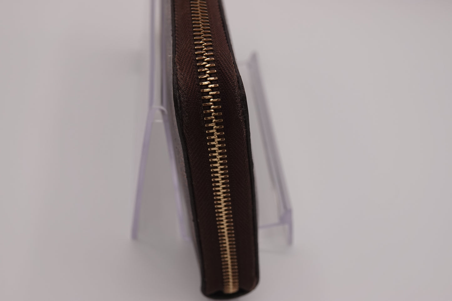 Close-up of a brown zipper on a white background