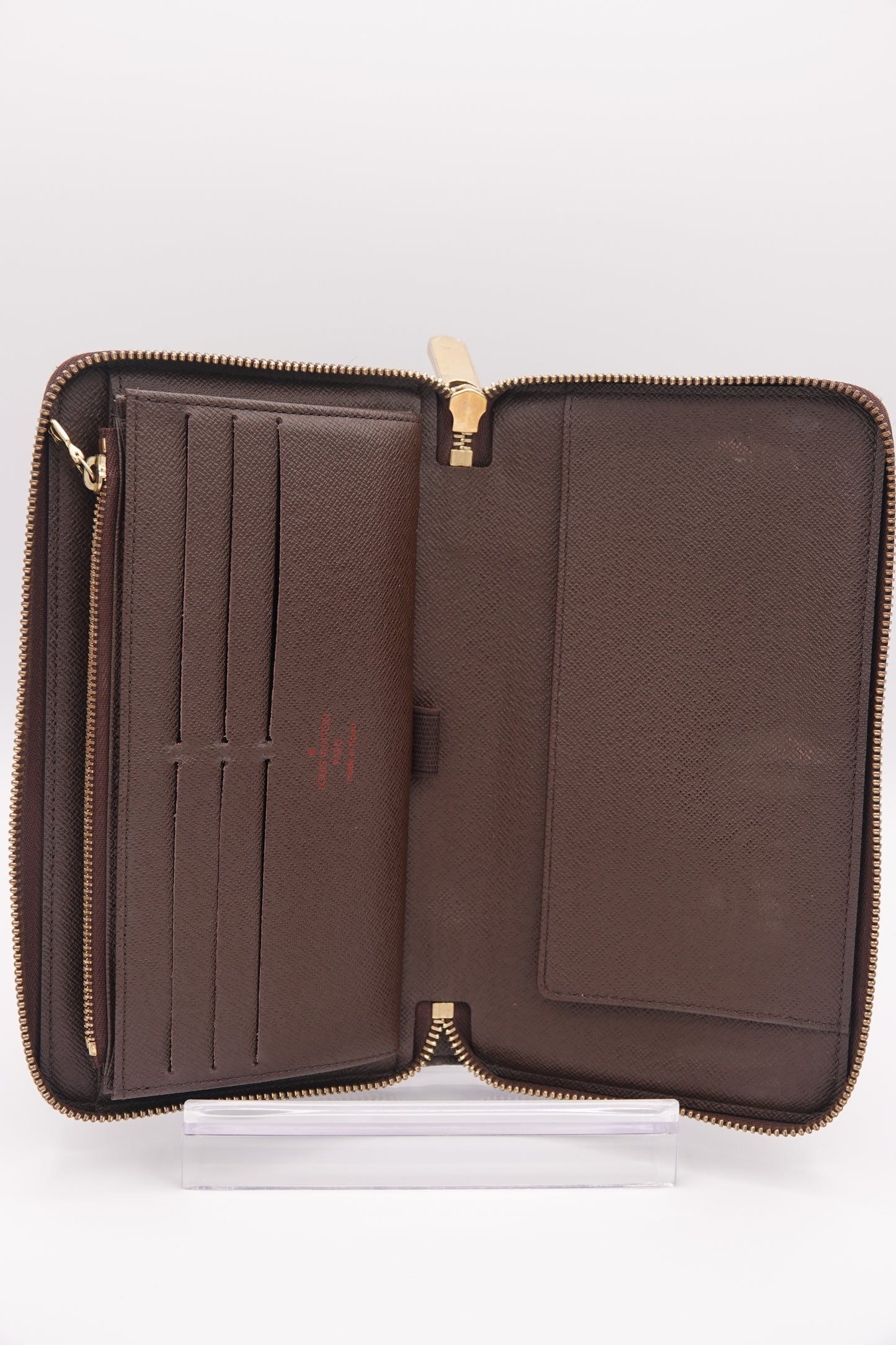 Brown leather wallet with gold zipper on a white background