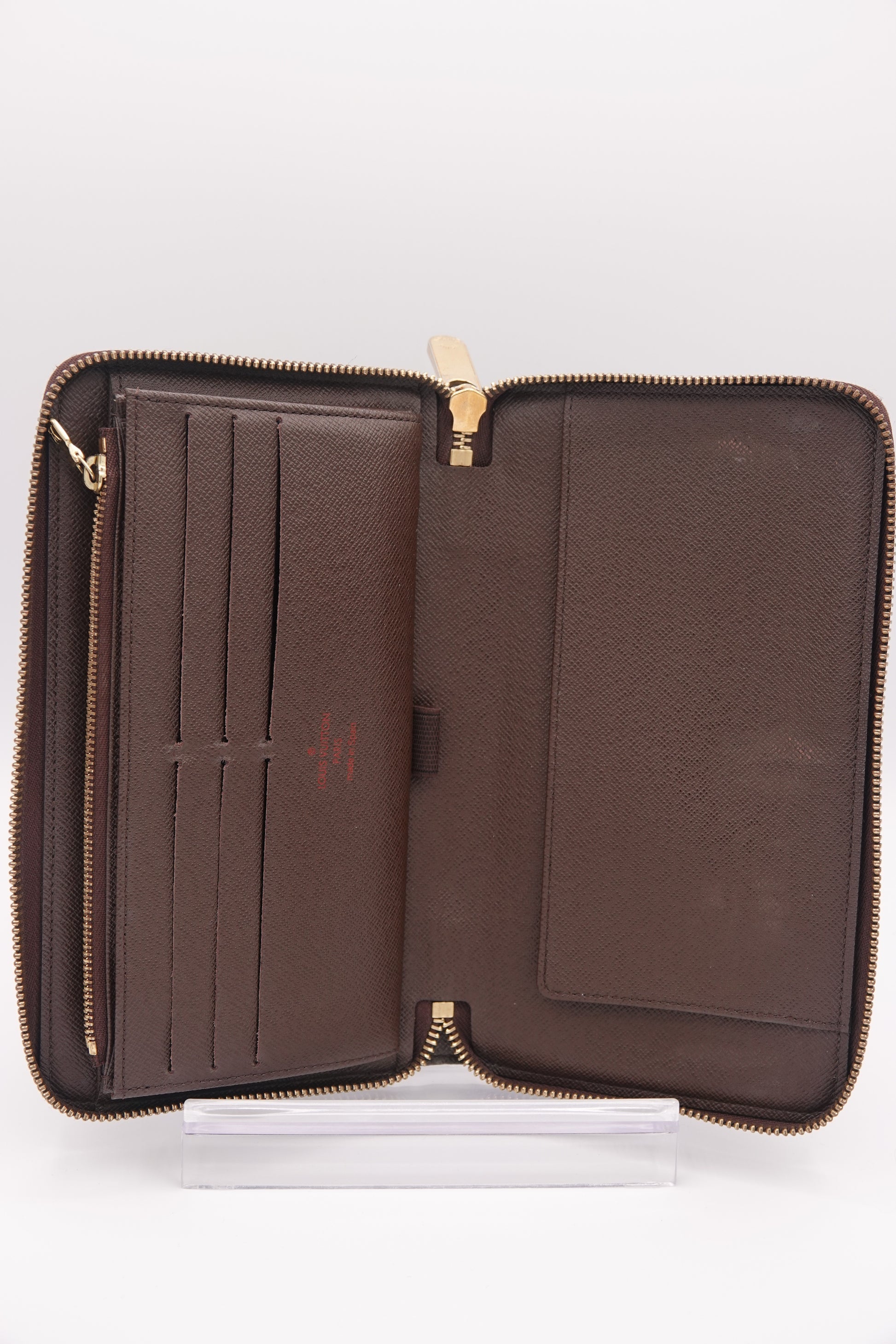 Brown leather wallet with gold zipper on a white background