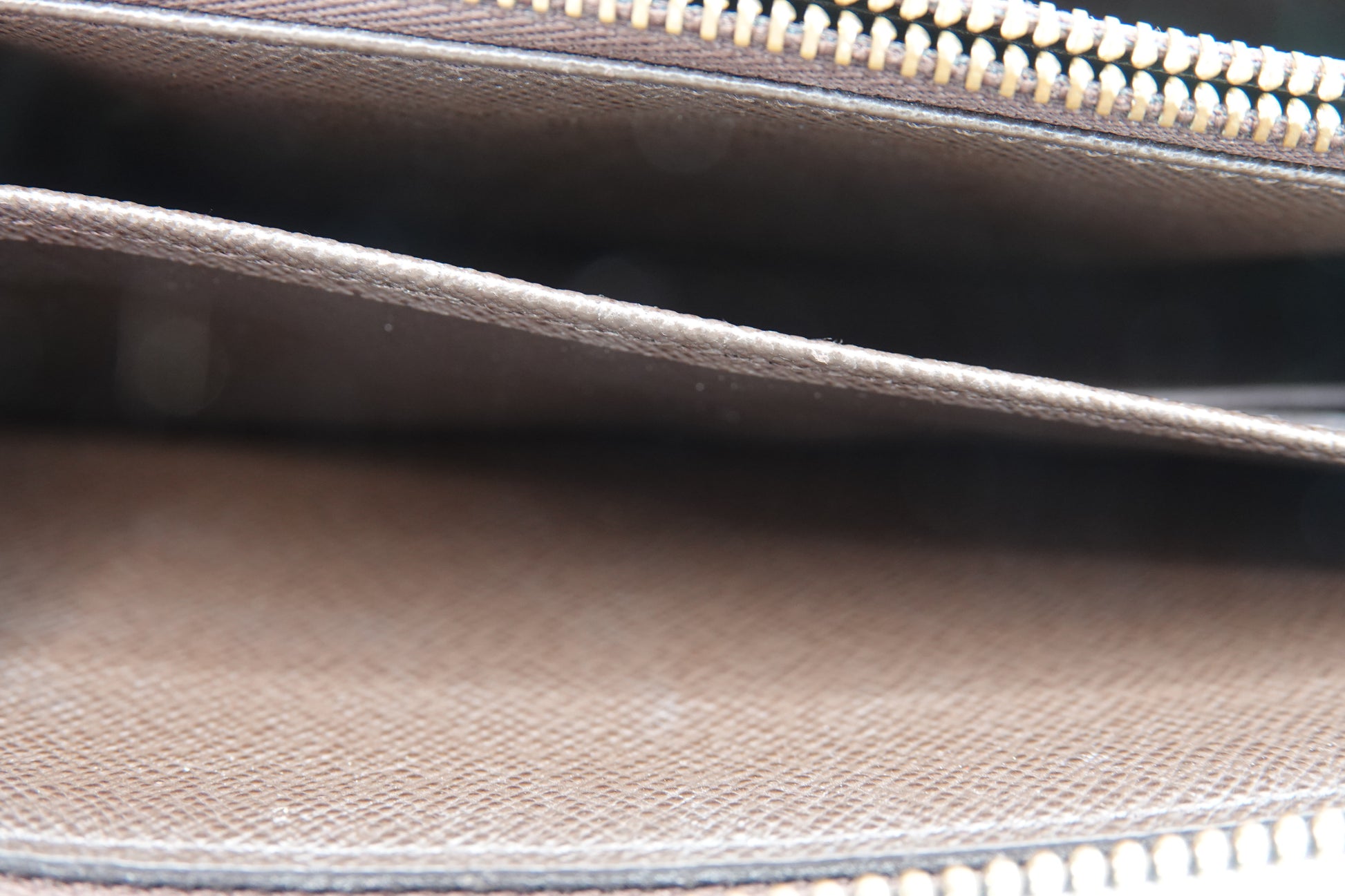 Close-up of a brown leather bag with a zipper