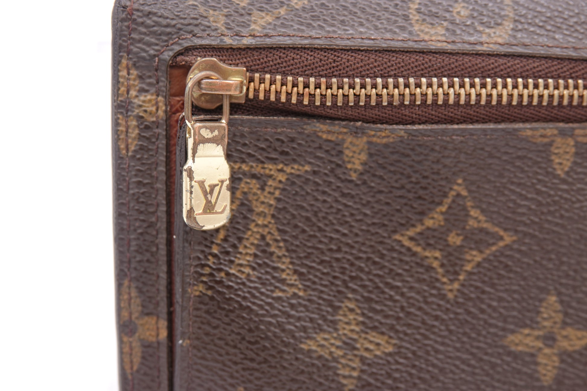 Close-up of a Louis Vuitton monogram handbag with a gold zipper.