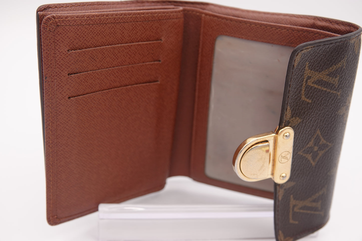 Brown leather wallet with gold clasp on a white background