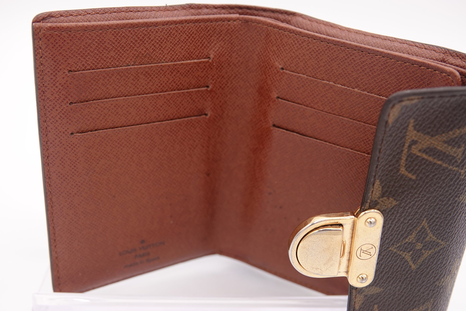 Brown wallet with gold clasp on a white background