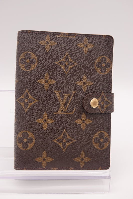 Louis Vuitton wallet with monogram pattern on a white background