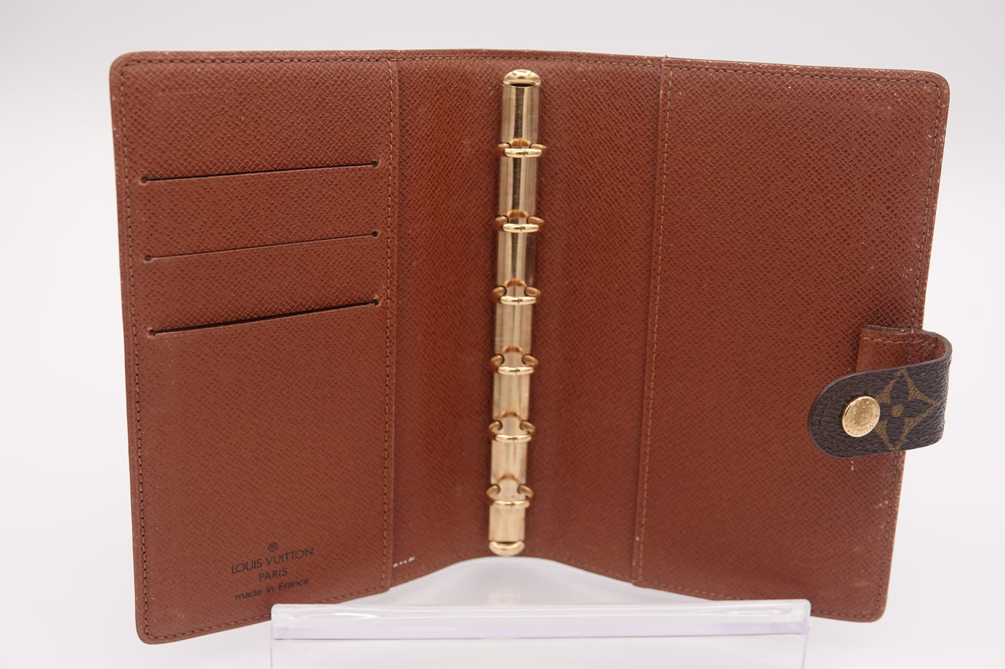Brown leather wallet with gold accents on a white background