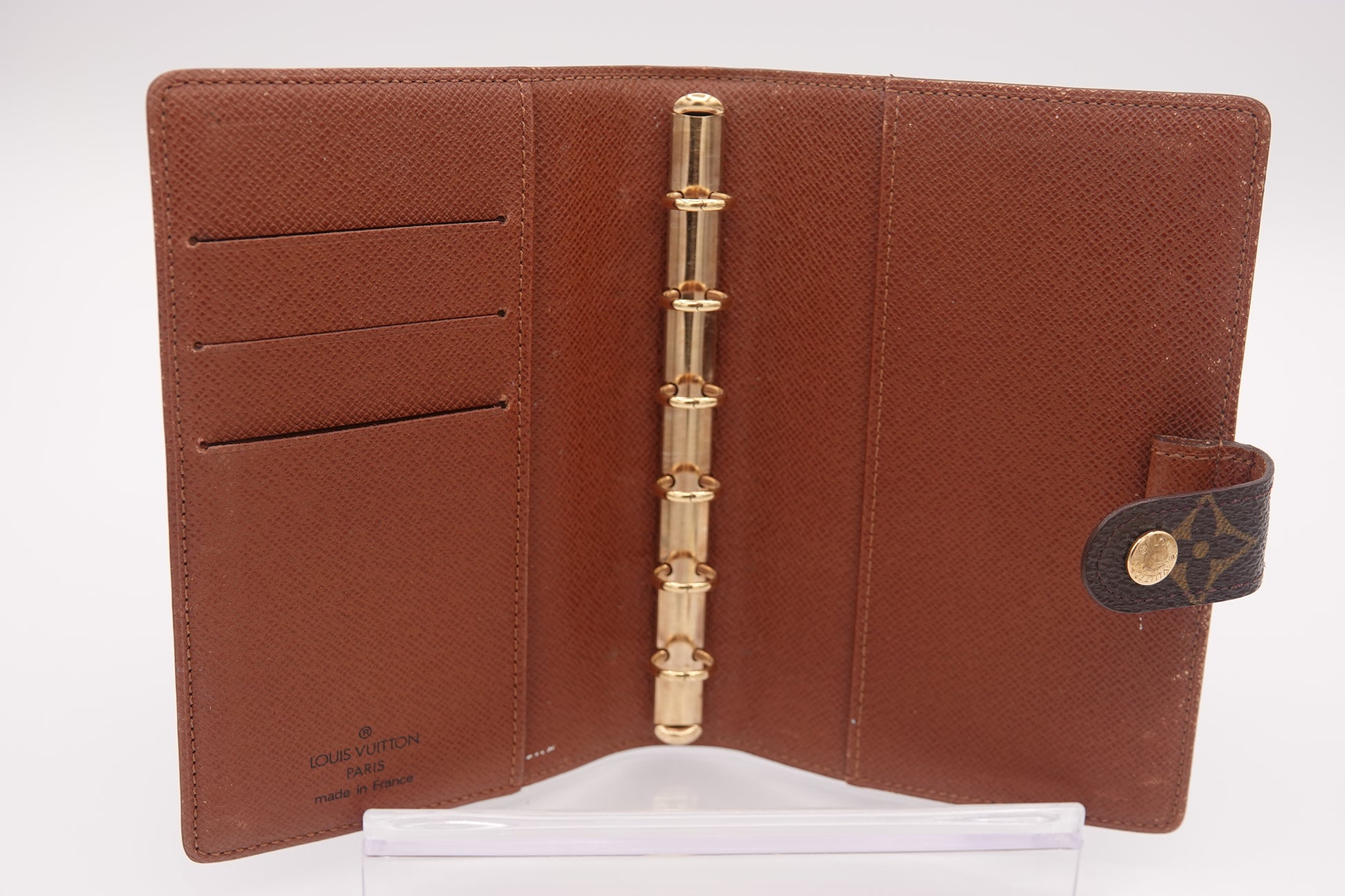 Brown leather wallet with gold accents on a white background
