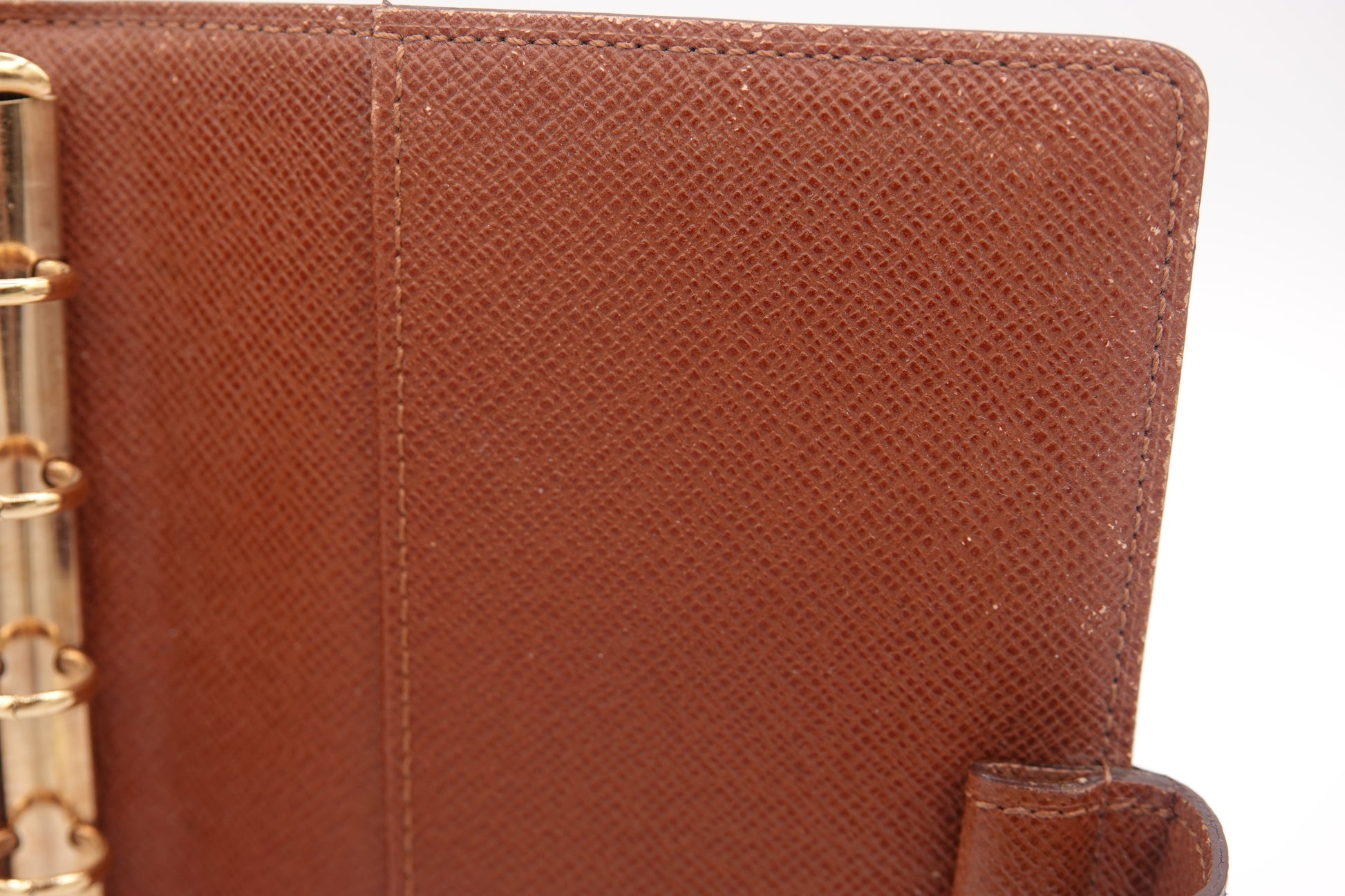 Close-up of a brown leather wallet with gold accents on a white background