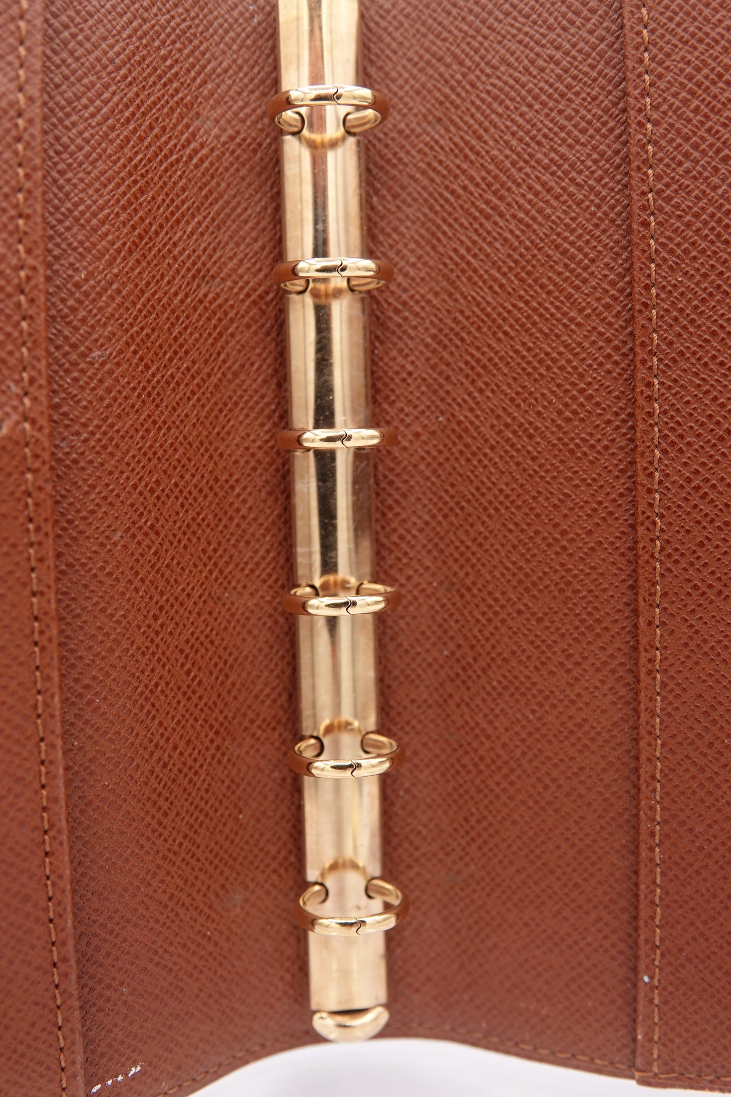 Close-up of a gold bracelet on a brown leather surface