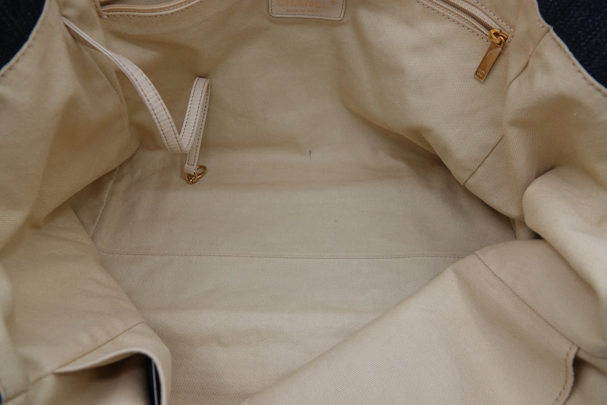 Close-up of a beige jacket with a brand label on a dark background