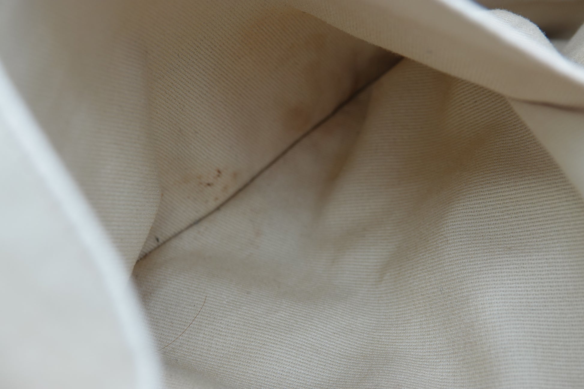 Close-up of beige fabric with a small stain