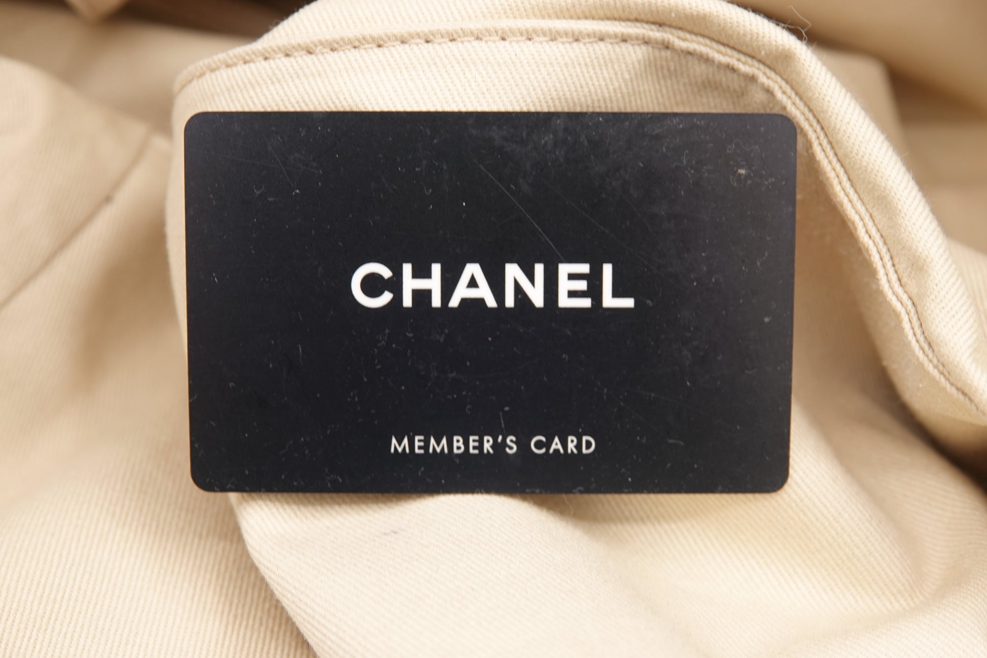 Chanel member's card on a beige fabric background