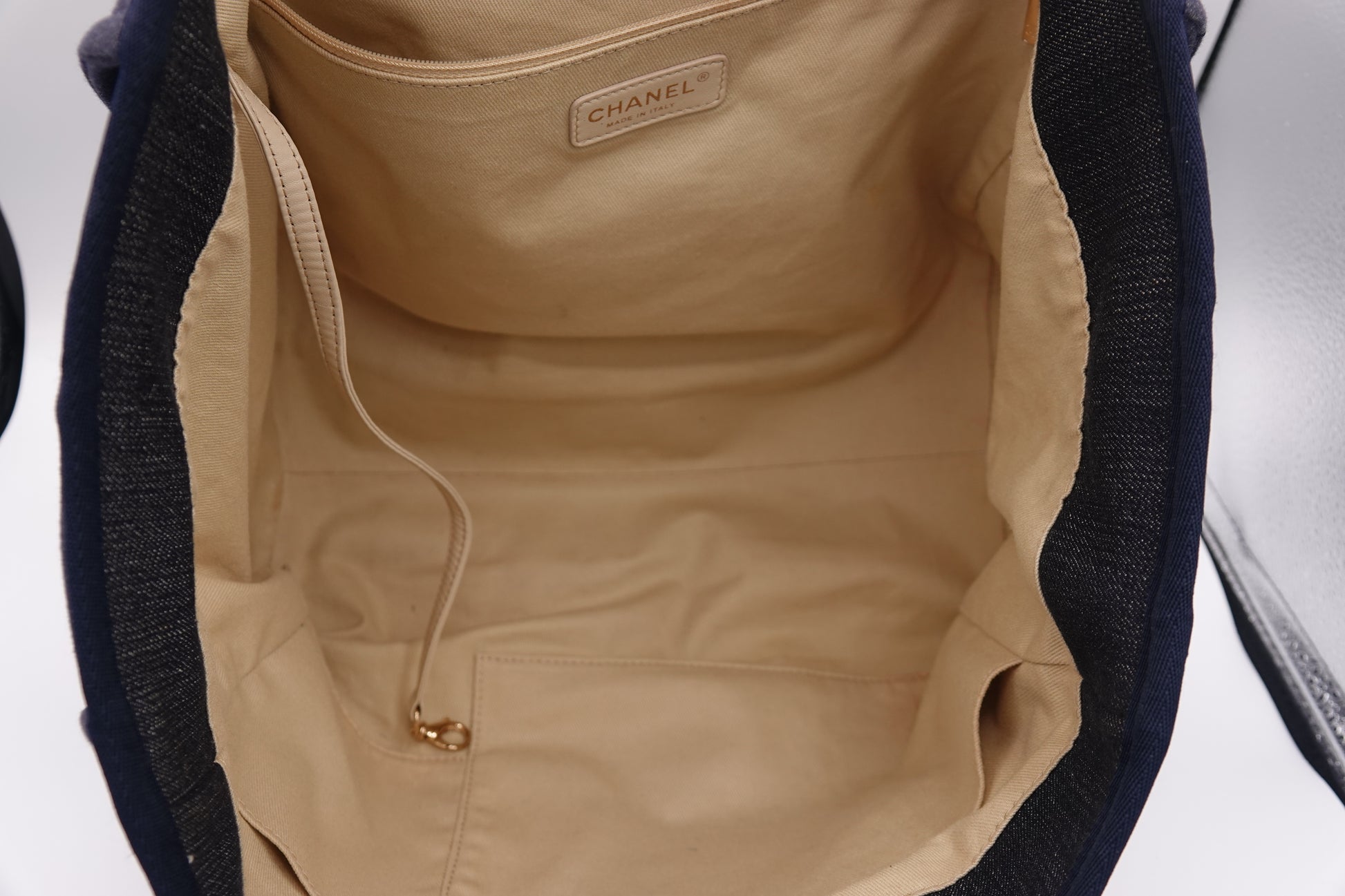 Close-up of a Chanel bag interior with beige lining and visible brand logo.