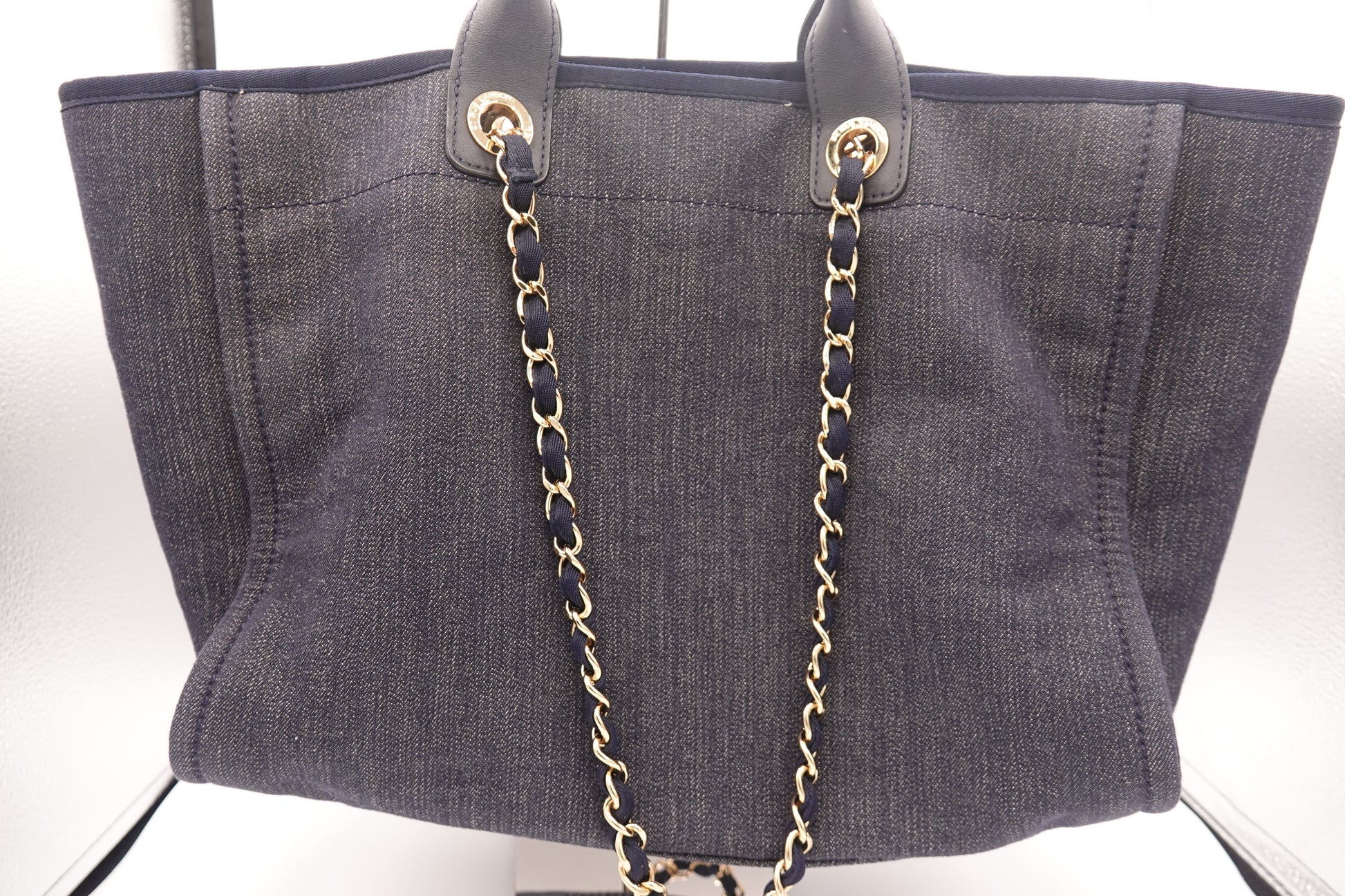 Gray tote bag with a gold chain strap on a white background