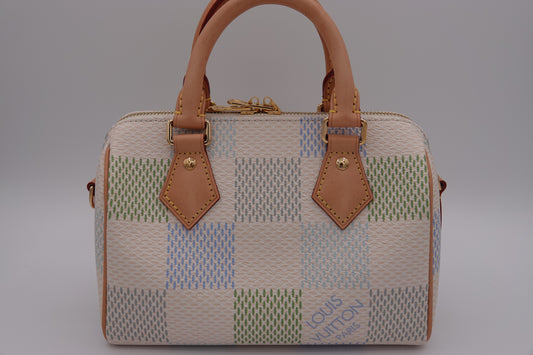 Patchwork handbag with brown leather handles and accents on a gray background