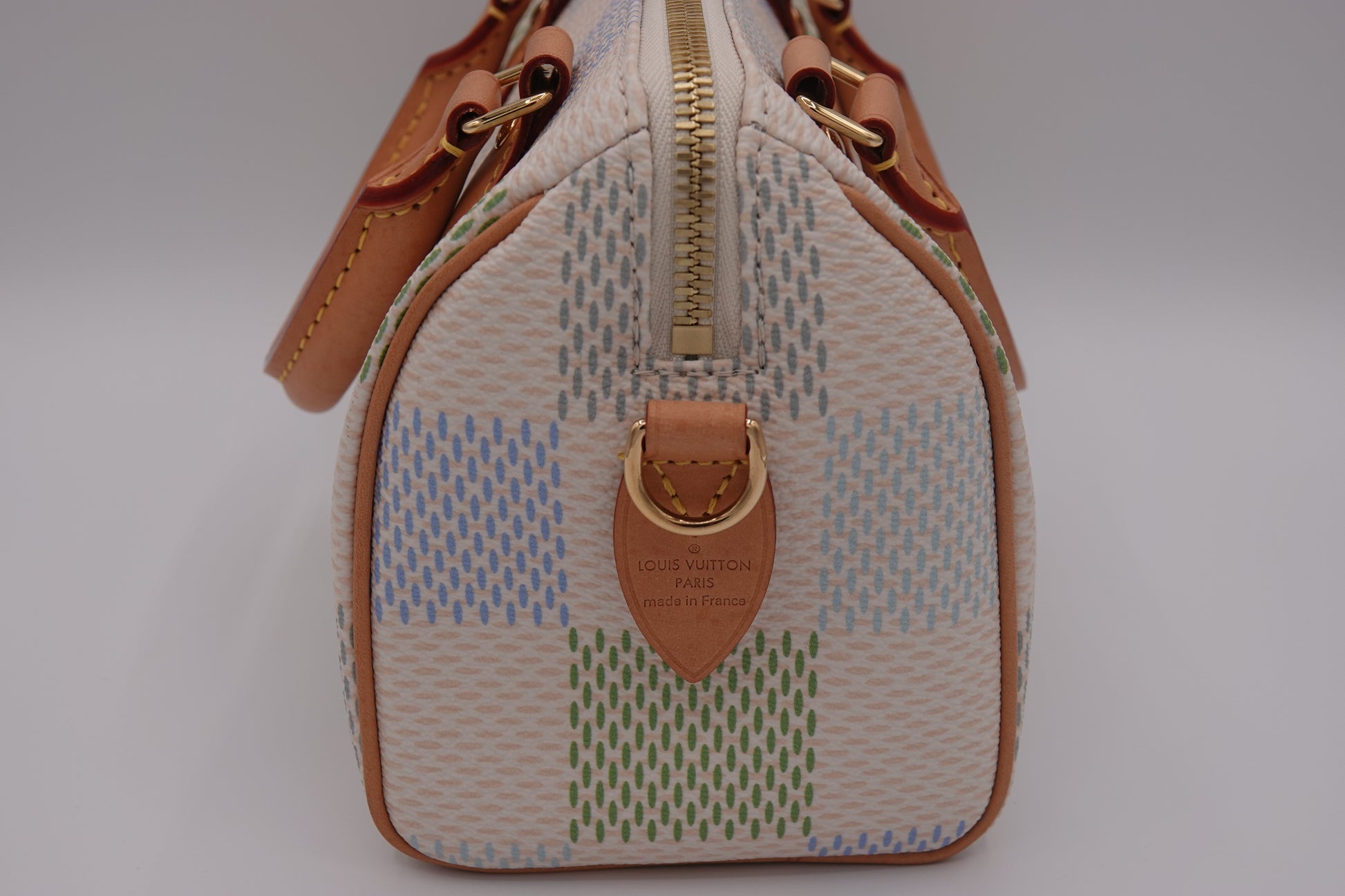 Small handbag with a patterned design and brown accents on a light gray background