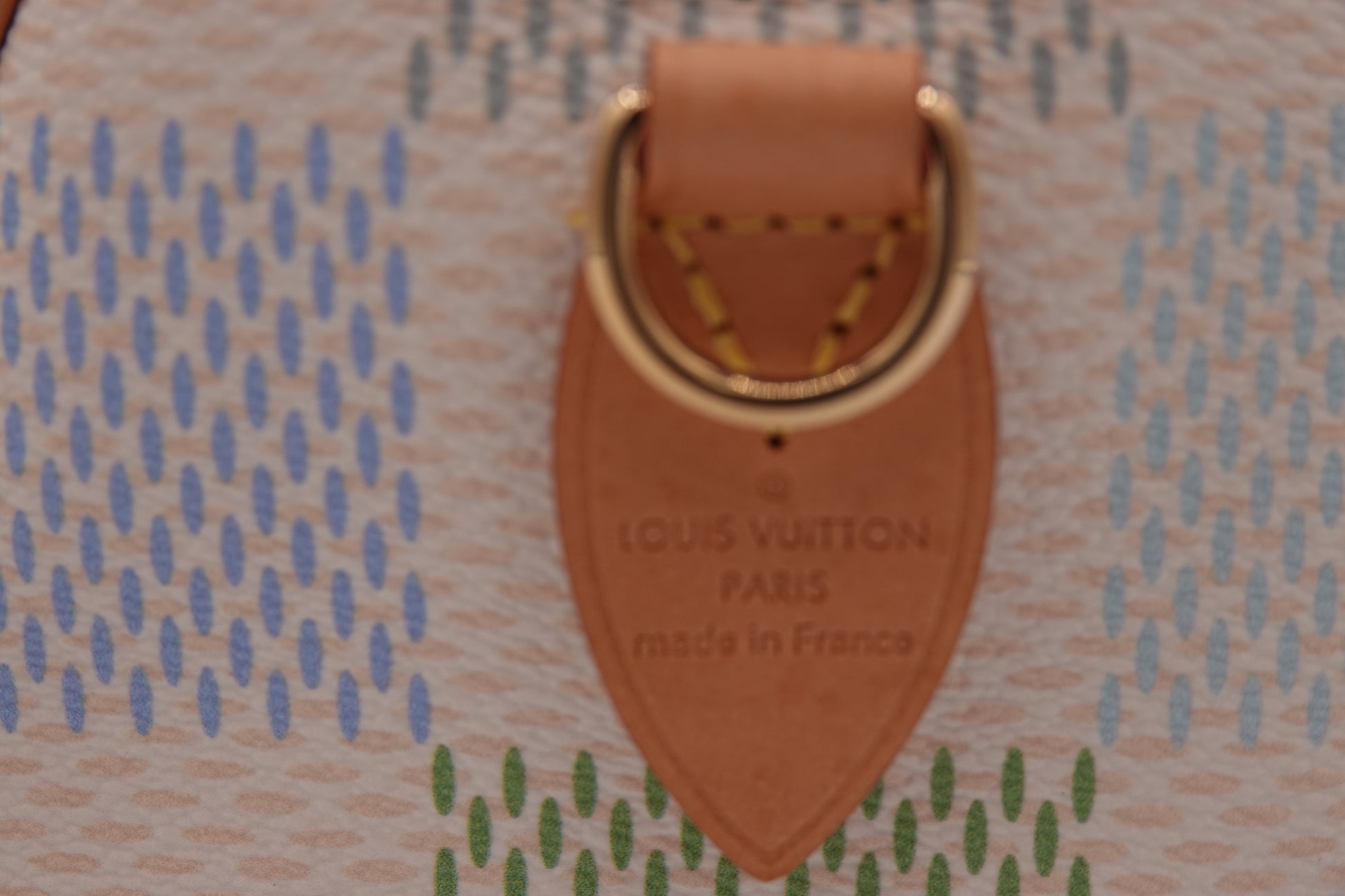 Louis Vuitton suitcase with a patterned design and leather tag.