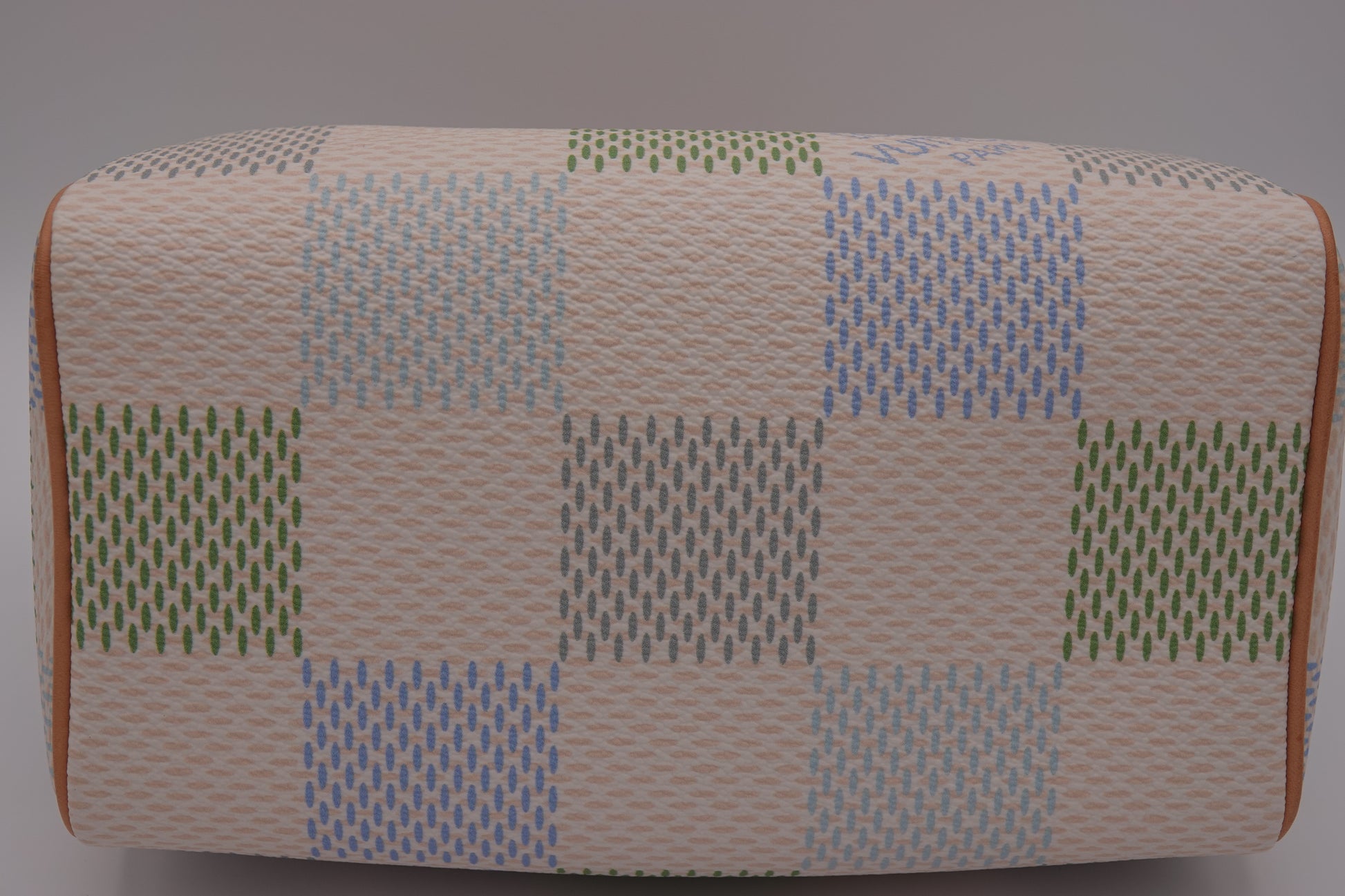 Rectangular ottoman with a patchwork pattern on a gray background