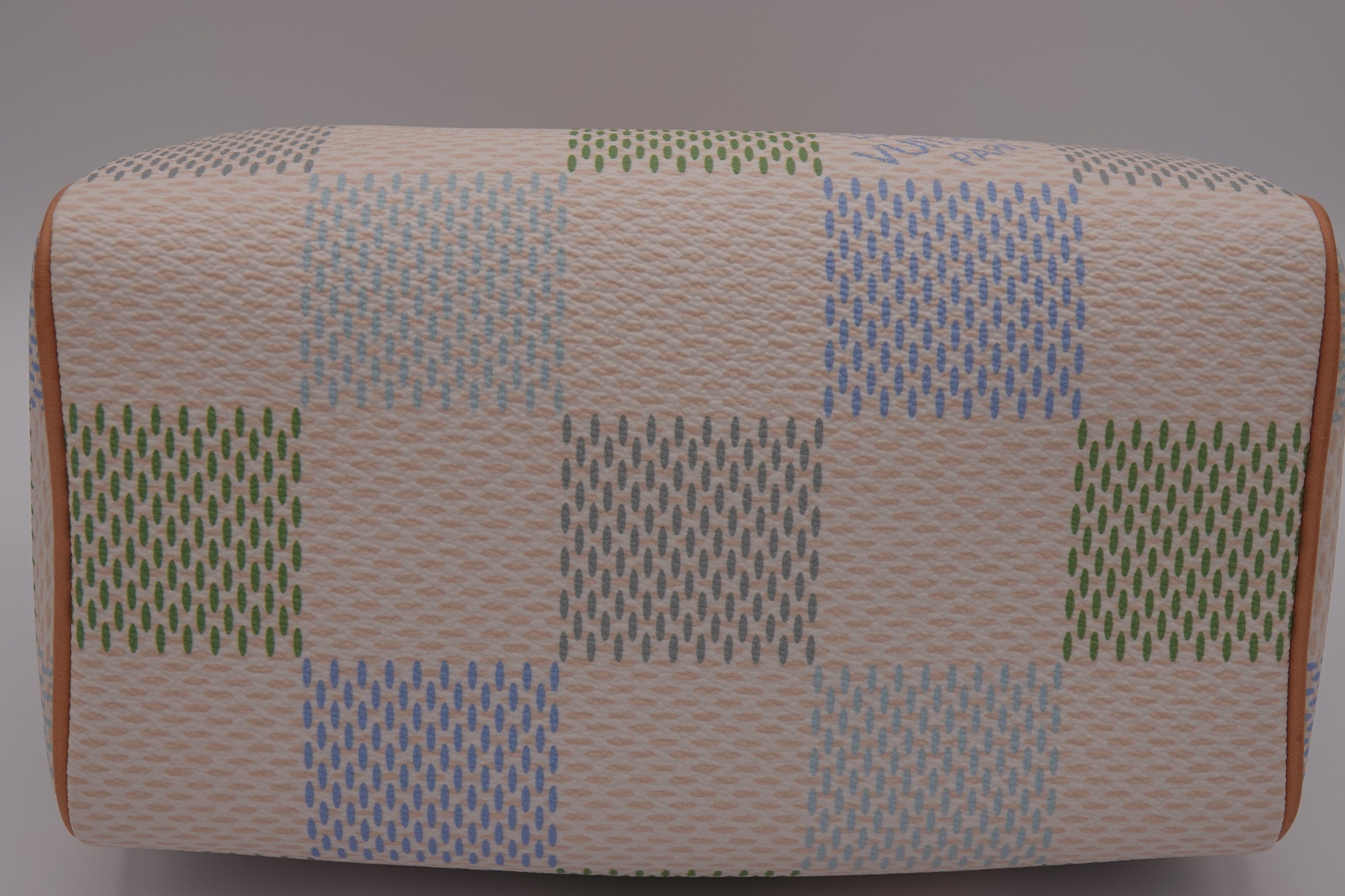 Rectangular ottoman with a patchwork pattern on a gray background