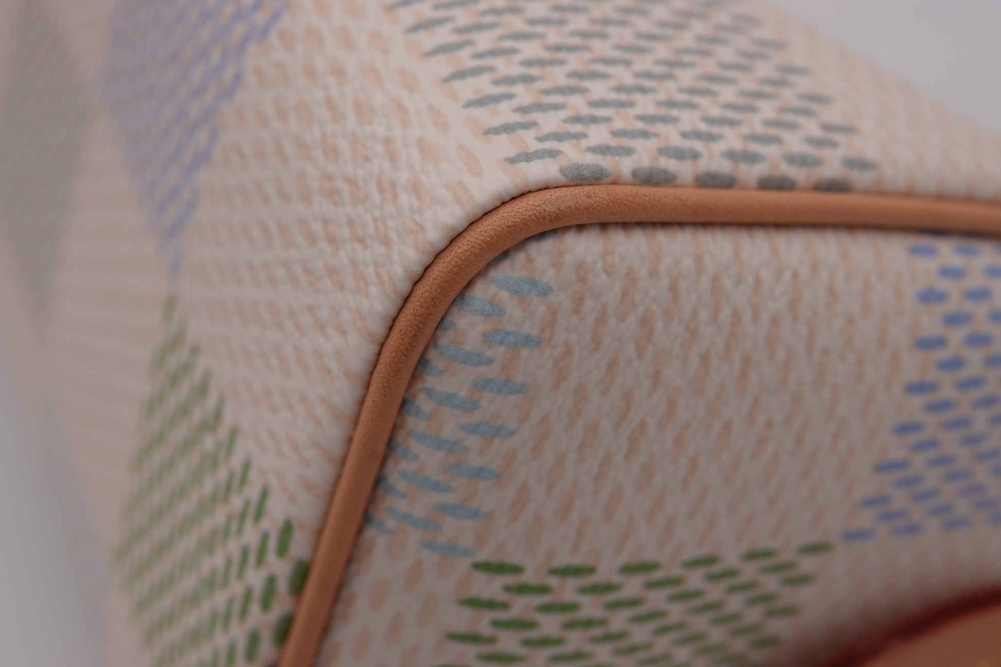 Close-up of a textured fabric with a pattern and brown border on a white background