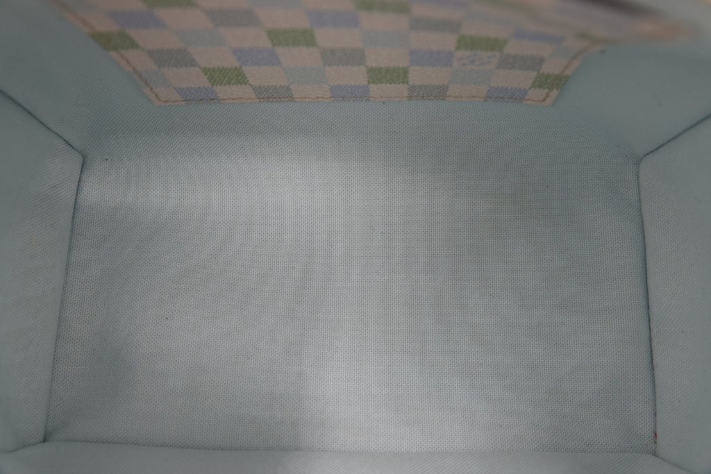 Close-up of a textured light blue fabric surface with a checkered pattern at the top.