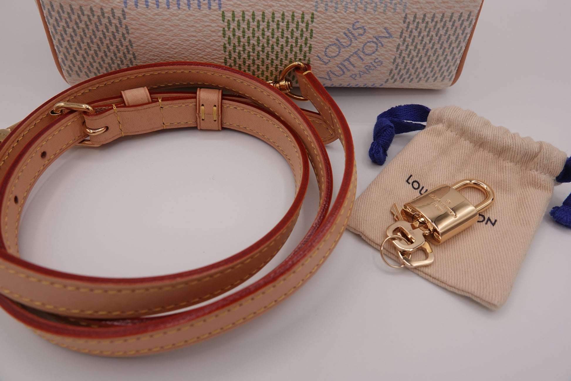 Louis Vuitton dog leash and gold clip with packaging on a white background
