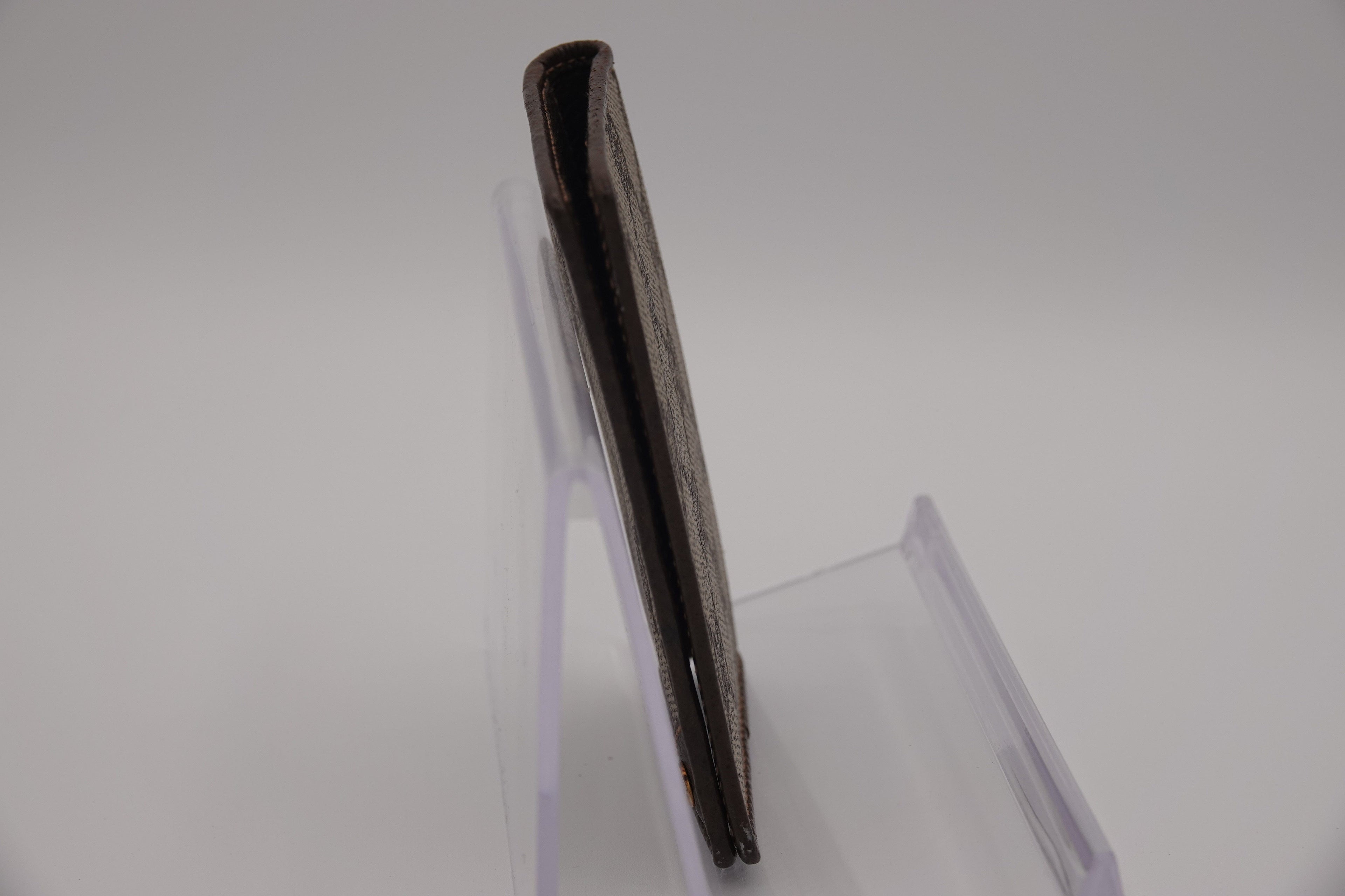 Black rectangular object on a clear stand against a white background