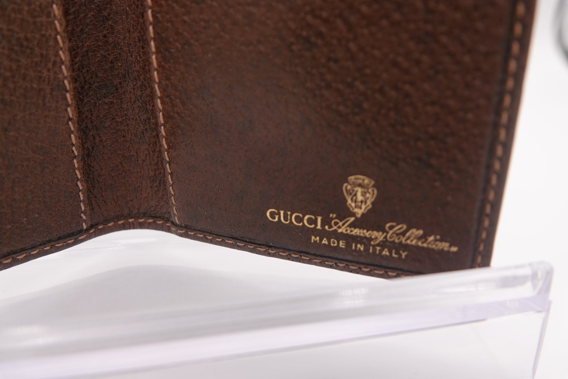 Brown leather Gucci wallet with visible logo on a white background