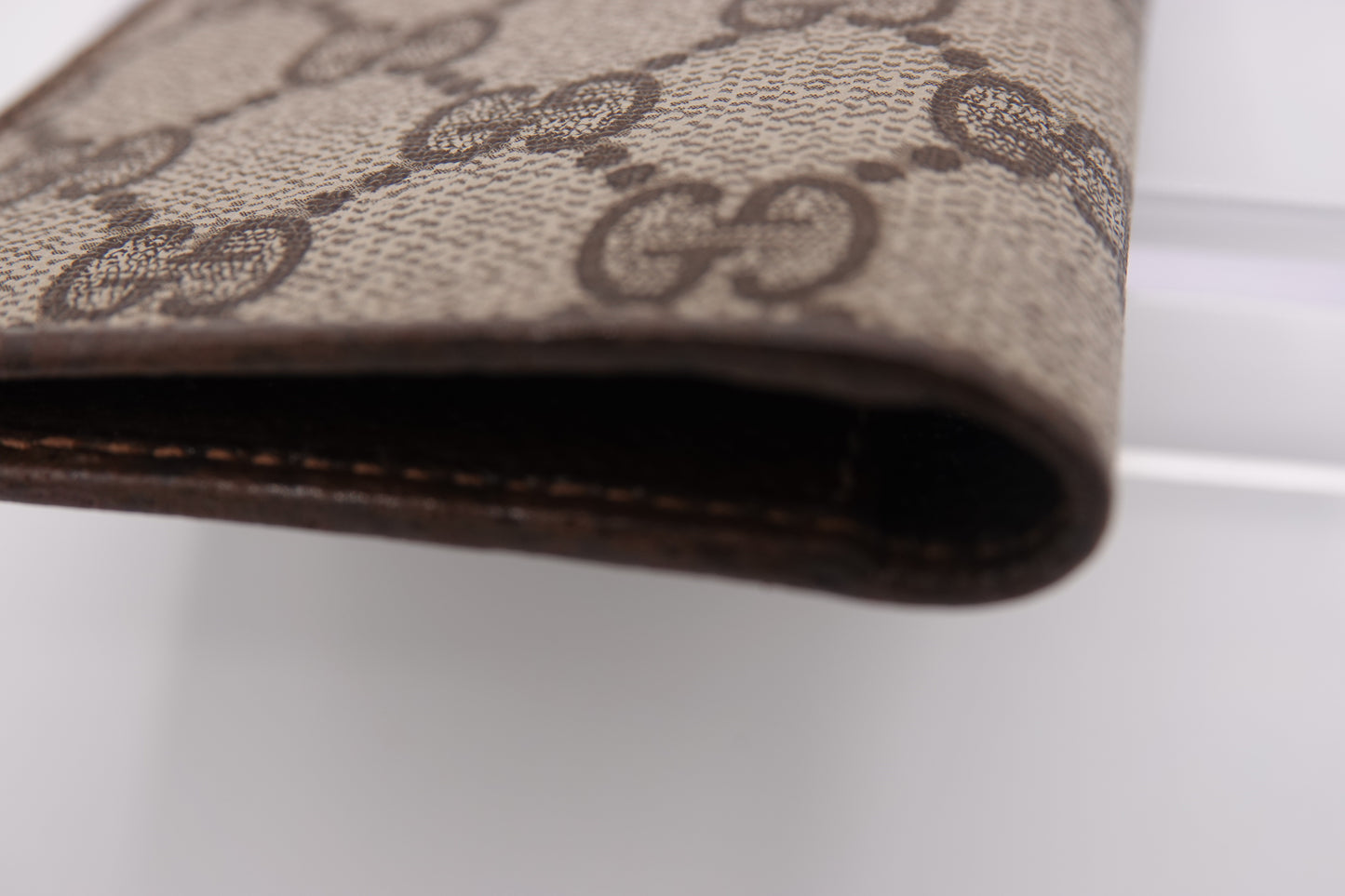 Close-up of a brown wallet with a patterned design on a white background