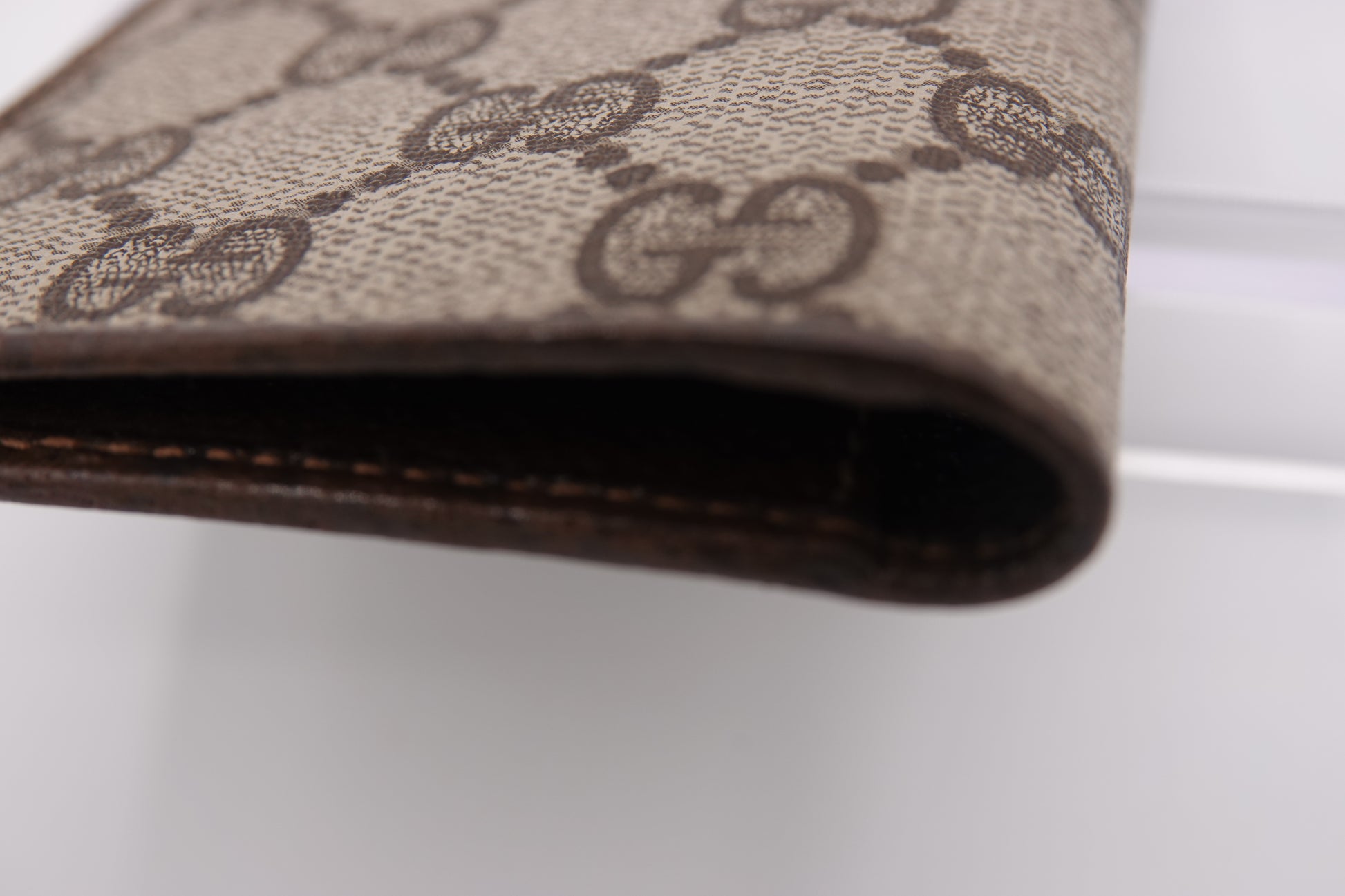 Close-up of a brown wallet with a patterned design on a white background
