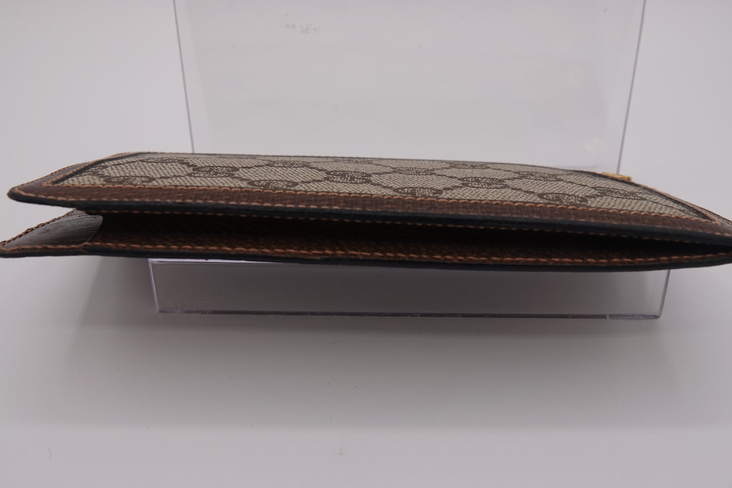 Brown leather clutch with pattern on a white background