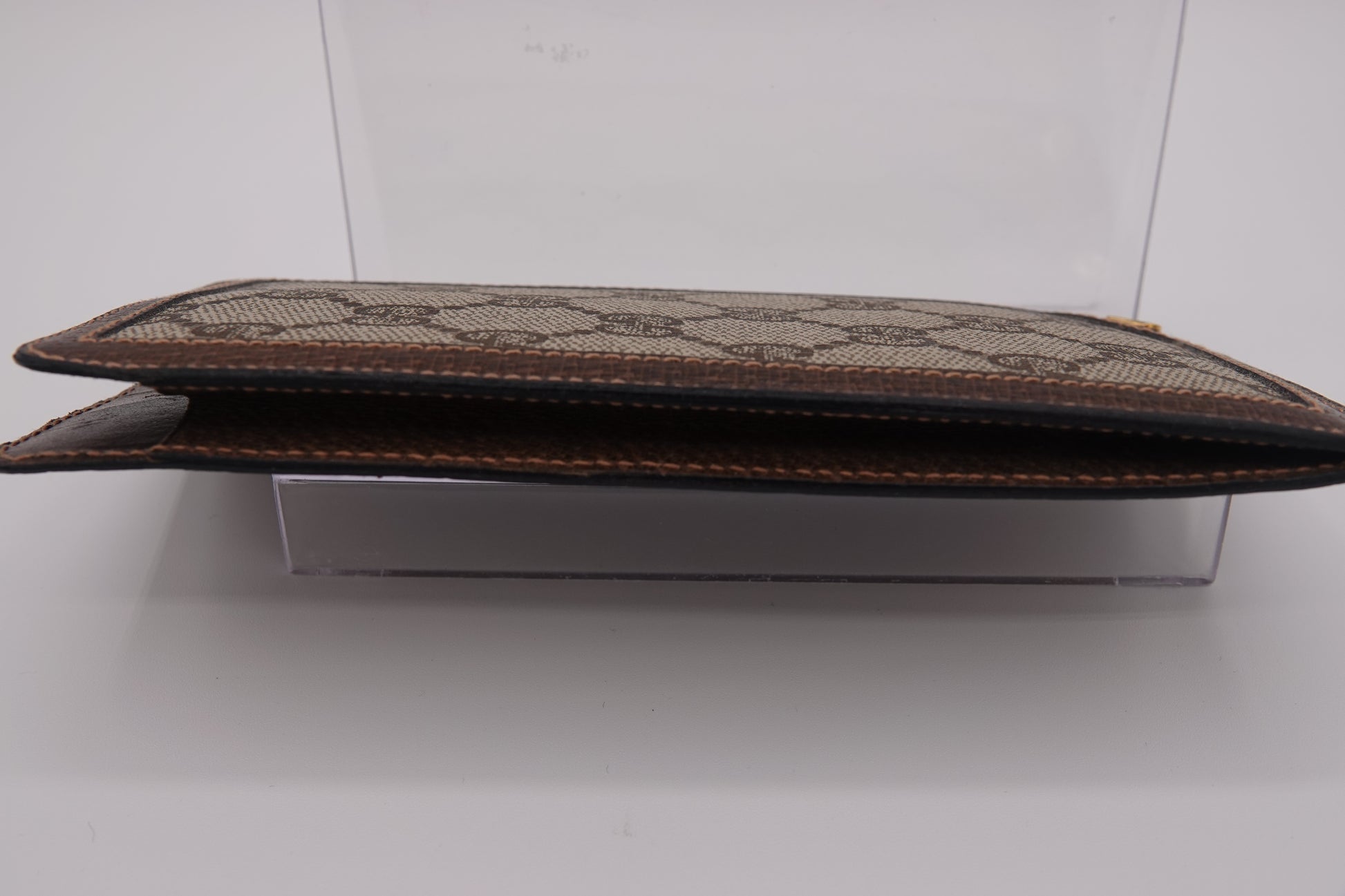 Brown leather clutch with pattern on a white background
