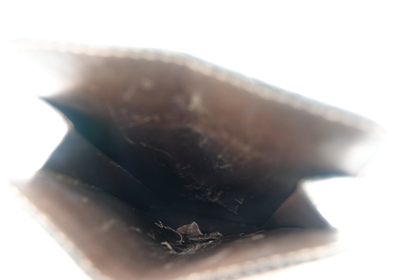 Close-up of a dark brown leather surface with visible texture and wear.