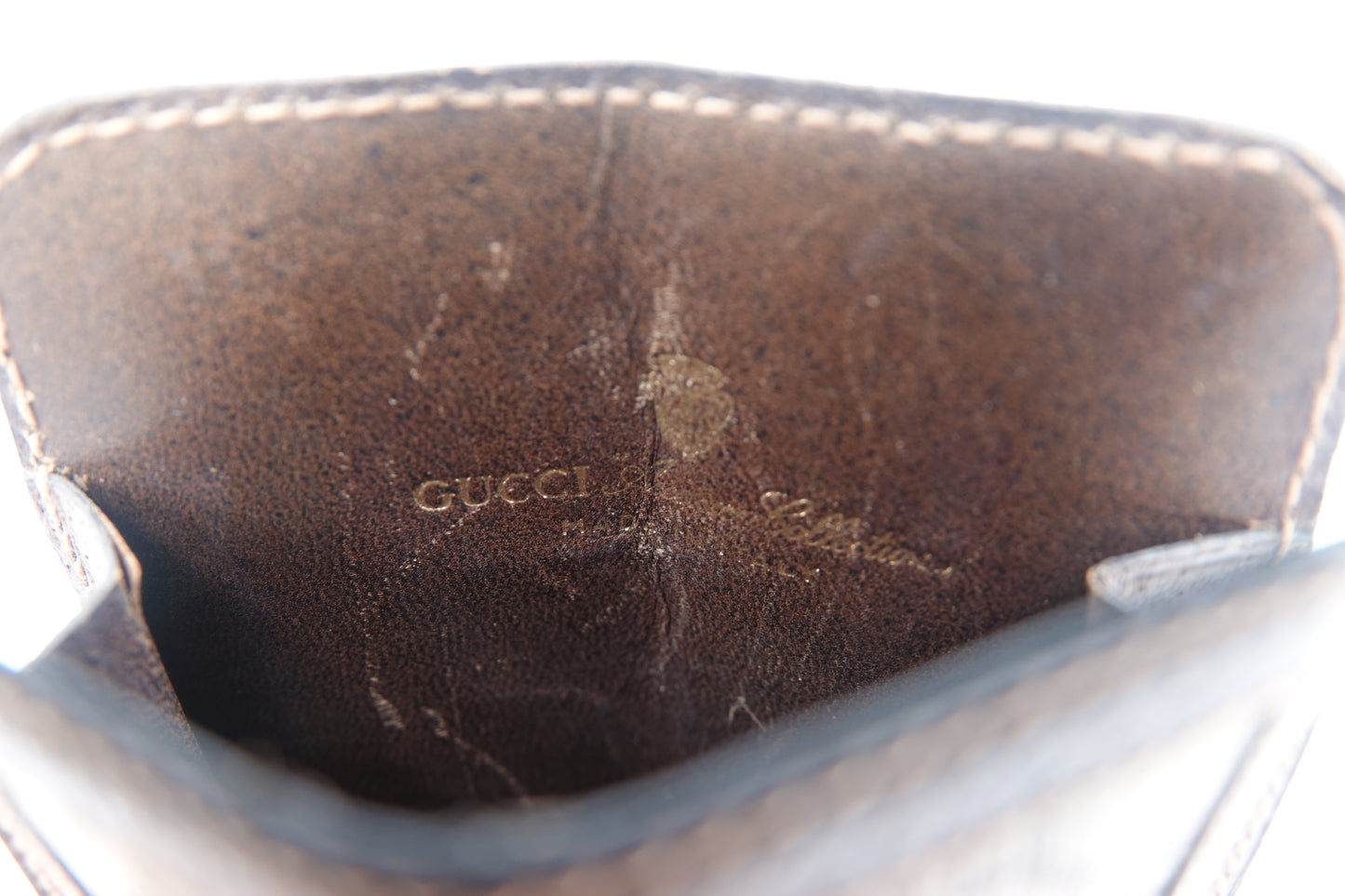 Close-up of a Gucci handbag with visible wear and tear.