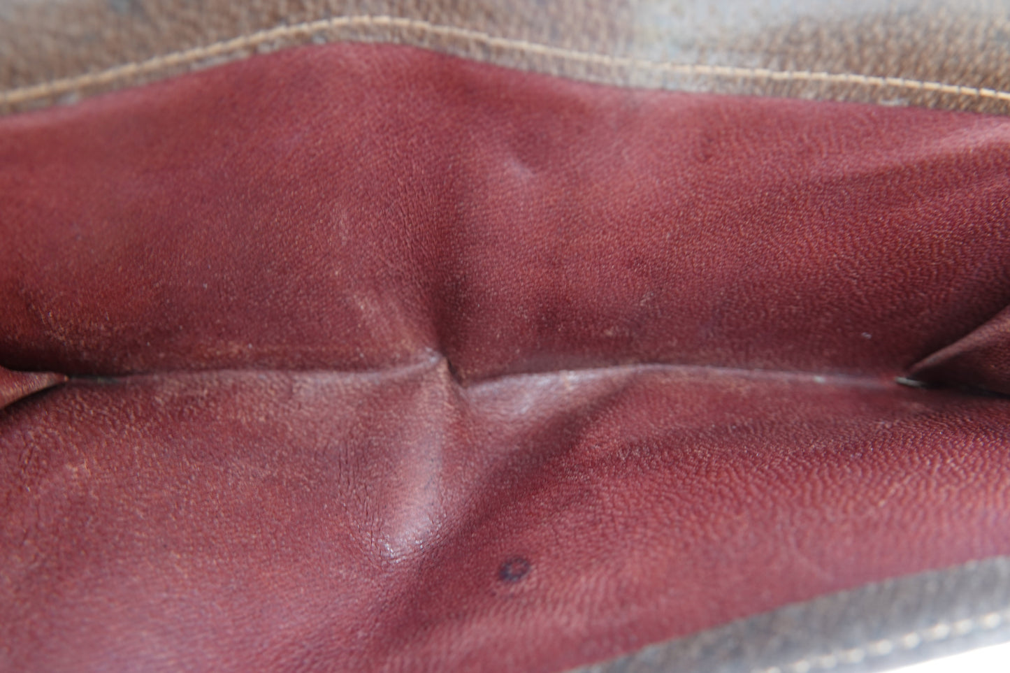 Close-up of a brown leather glove with visible wear.