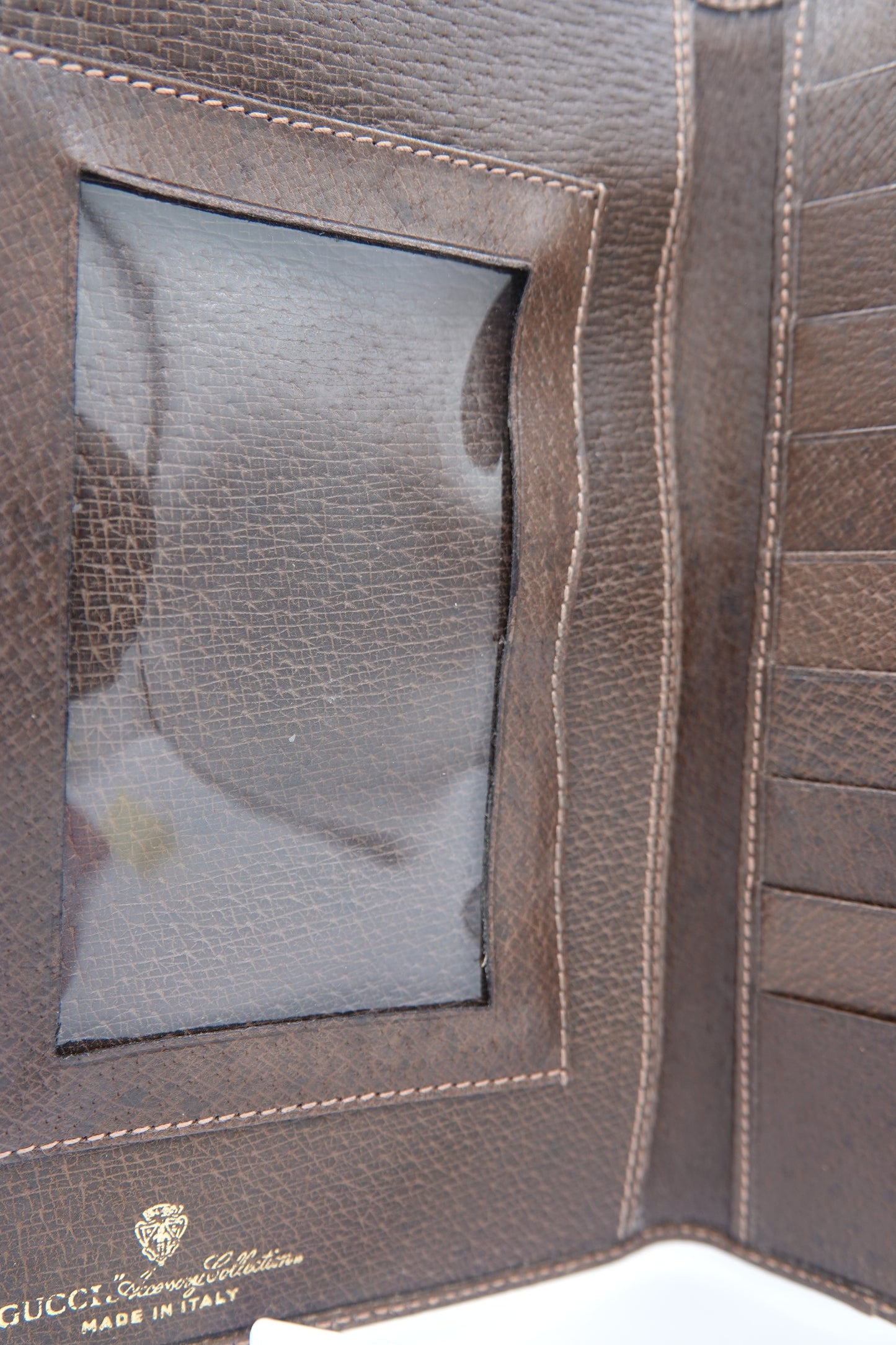 Close-up of a brown leather wallet with Gucci logo