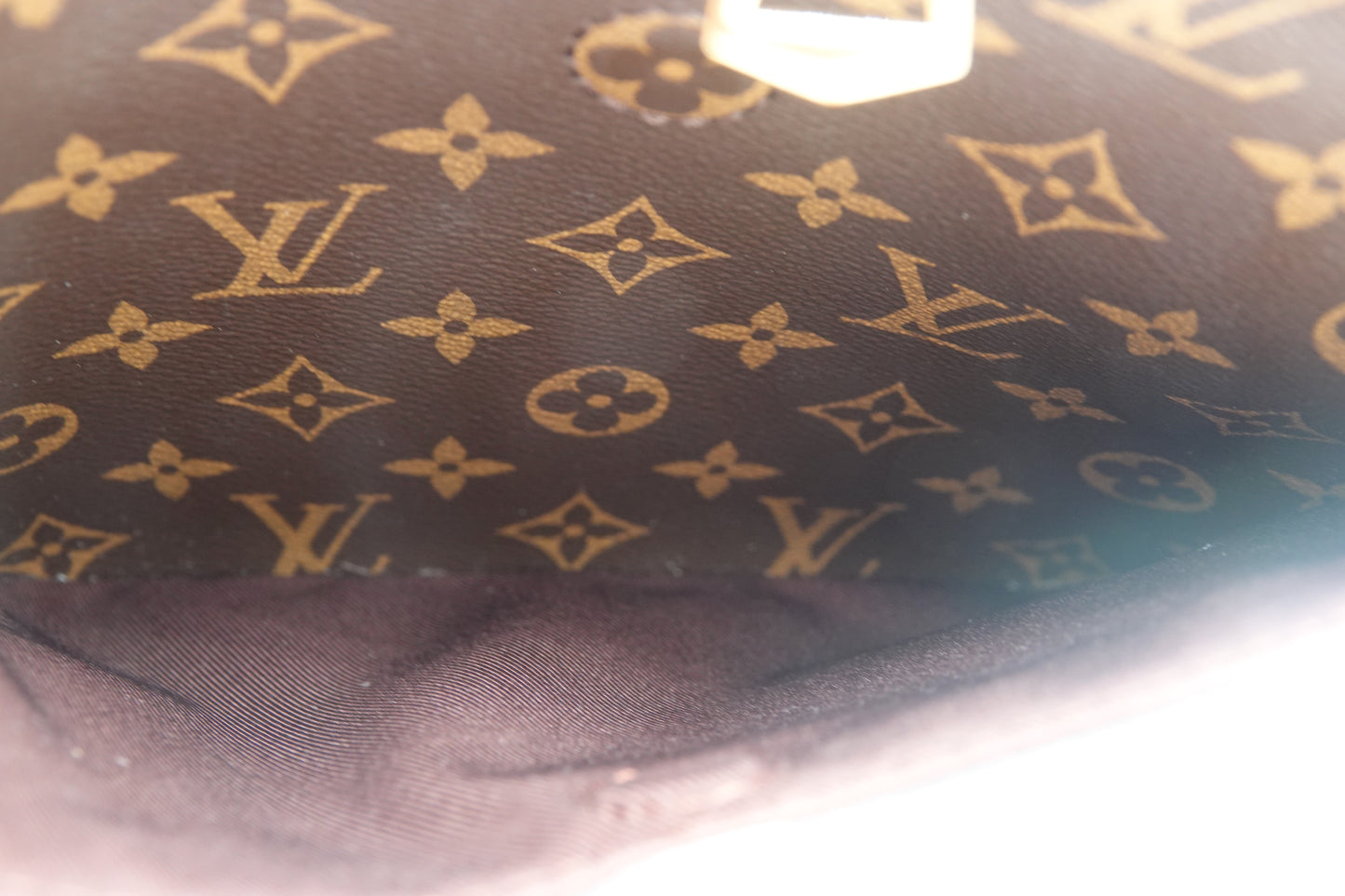 Close-up of a Louis Vuitton monogram pattern on a dark fabric background