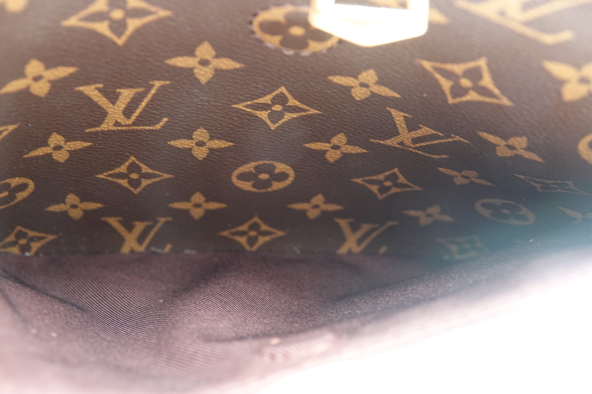 Close-up of a Louis Vuitton monogram pattern on a dark fabric background