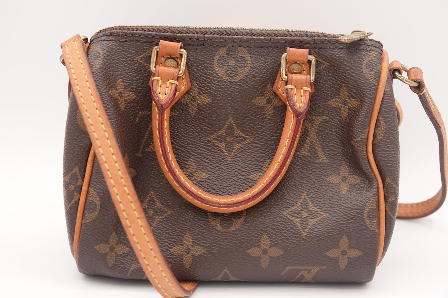 Brown handbag with monogram pattern on a white background